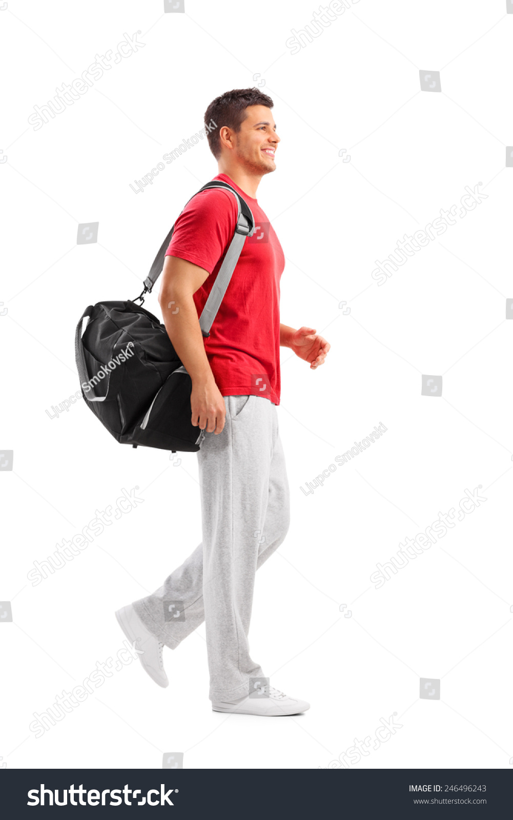 Full length portrait of a male athlete walking with a sports bag isolated on white background Full length portrait of a male athlete walking with a sports bag isolated on white background