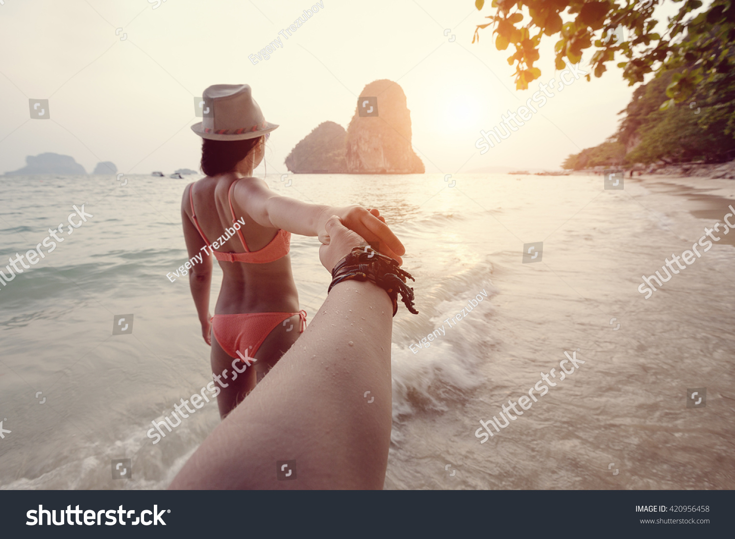 Girl in a bikini holding a hand Man on the beach in Thailand Girl in a bikini holding a hand Man on the beach in Thailand