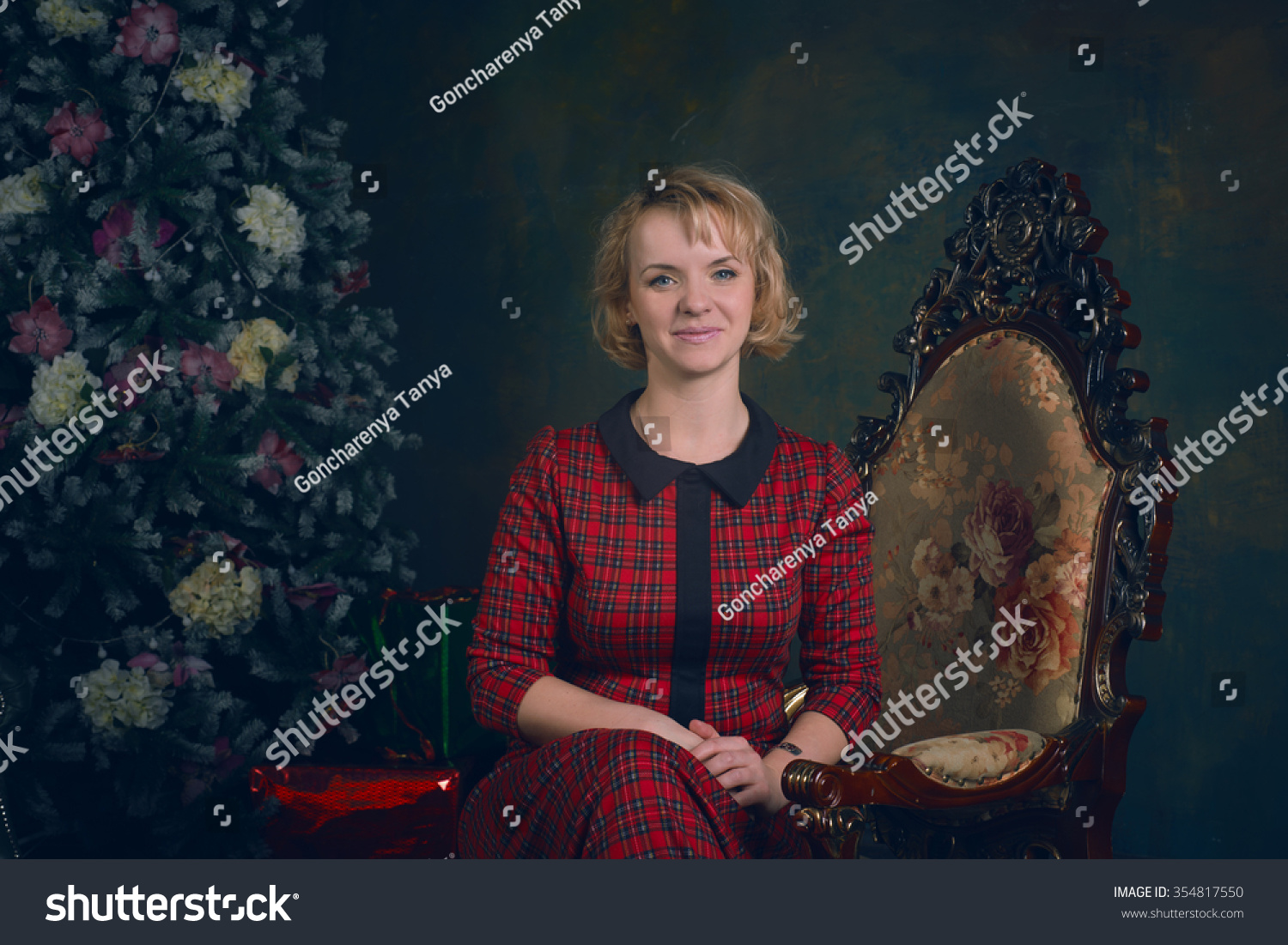 Girl in retro vintage dress sitting in the chair next to the Christmas tree Girl in retro vintage dress sitting in the chair next to the Christmas tree
