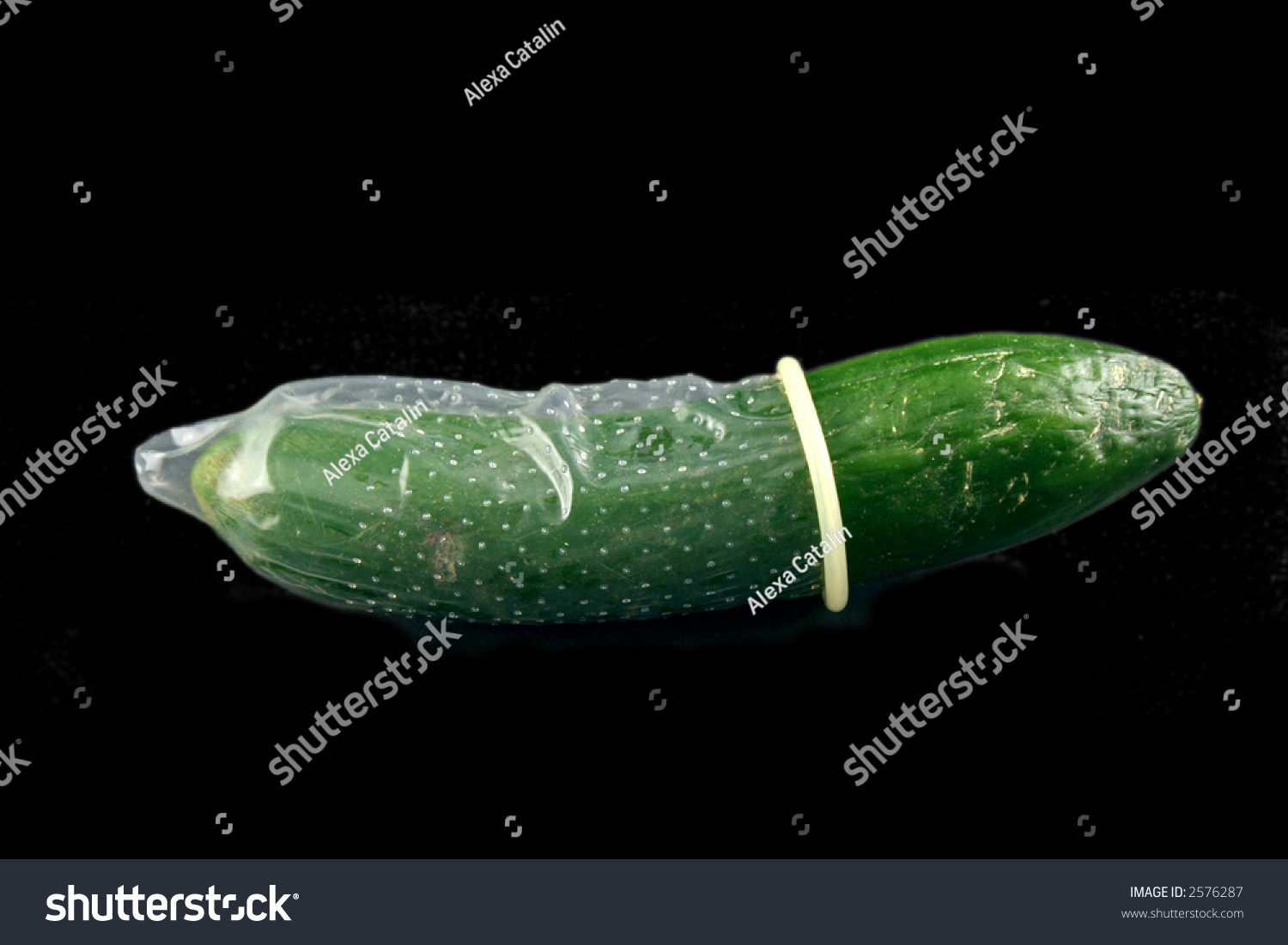 Green Cucumber With Condom On A Black Backgro
