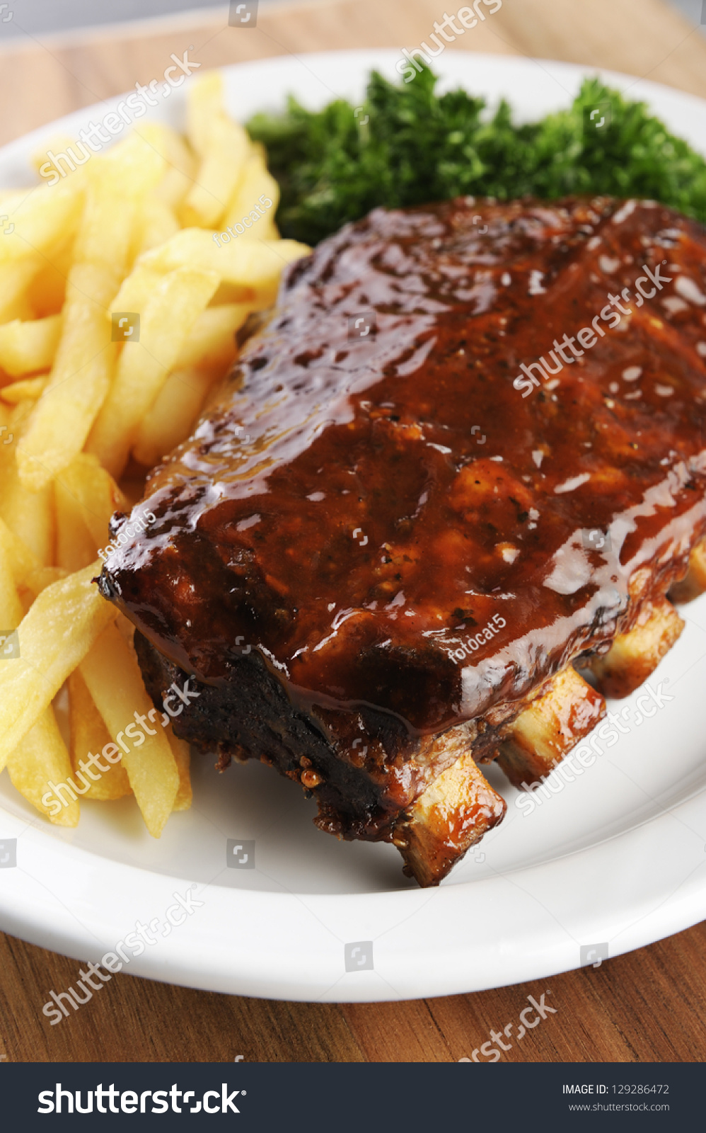 Grilled Juicy Barbecue Pork Ribs In A White Plate With Fries And ...