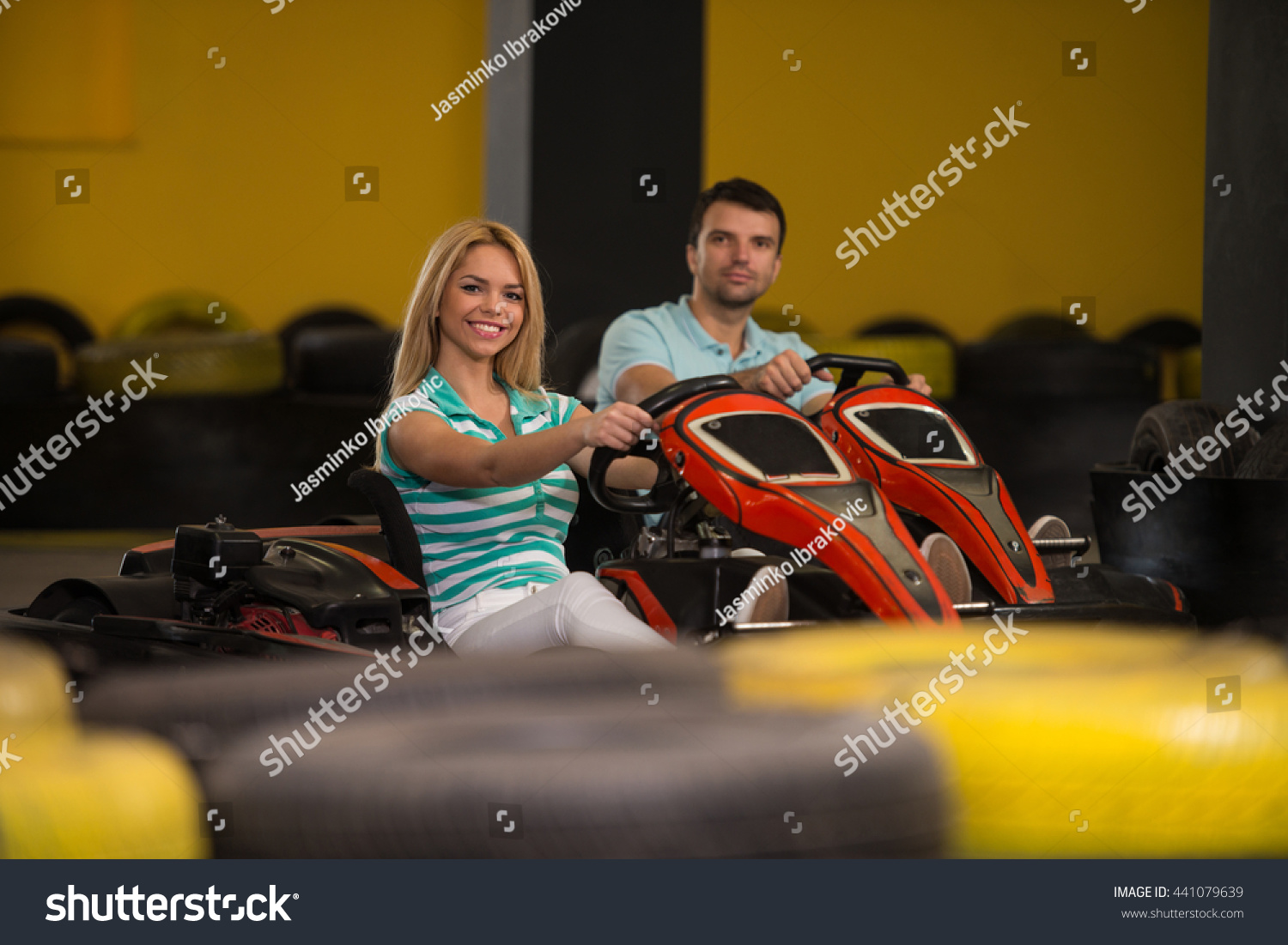Group Of People Is Driving Go-Kart Car With Speed In A Playground Racing Track Go Kart Is A Popular Leisure Motor Sports Group Of People Is Driving Go-Kart Car With Speed In A Playground Racing Track Go Kart Is A Popular Leisure Motor Sports