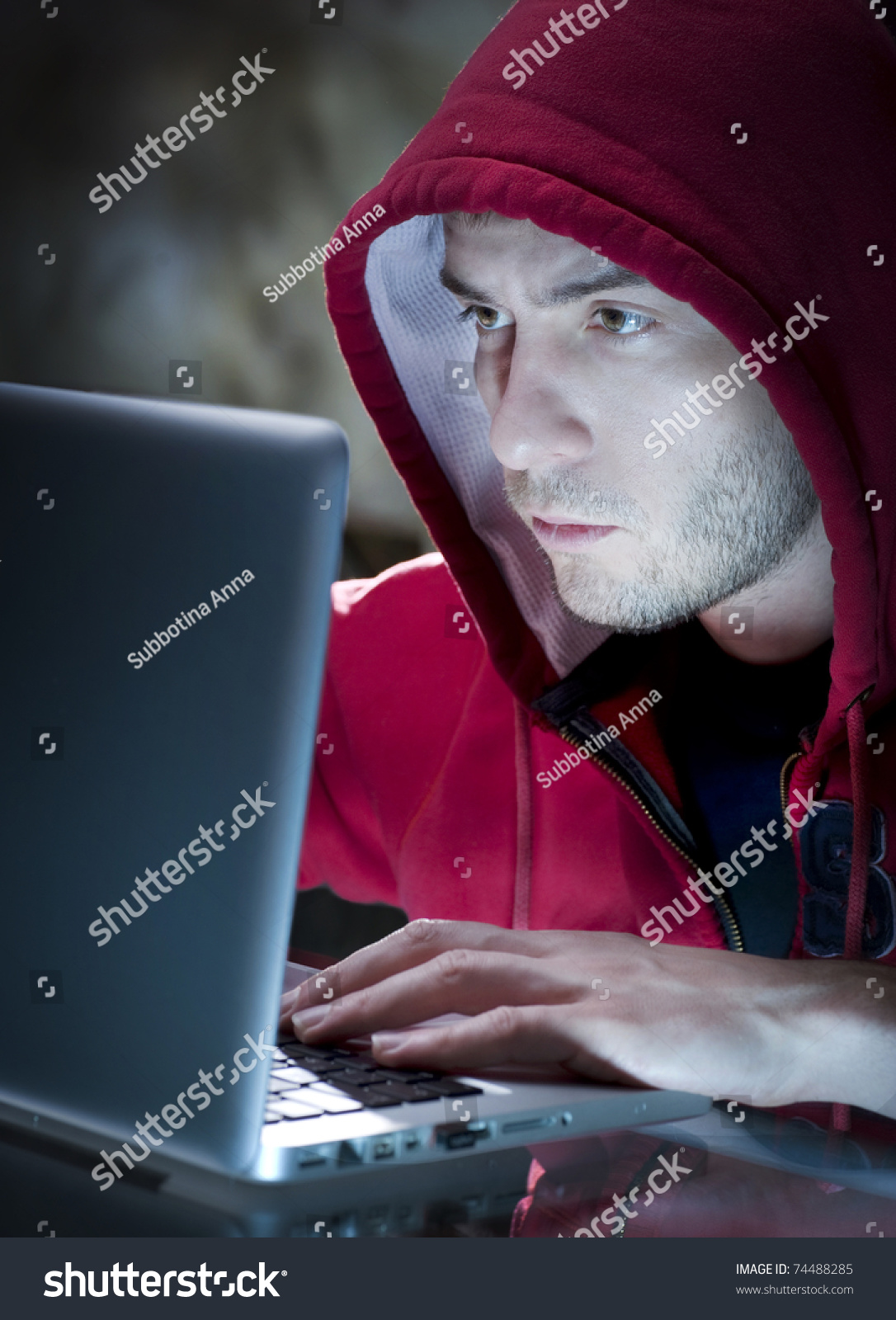 Save to a lightbox - stock-photo-hacker-man-with-computer-in-a-dark-room-74488285