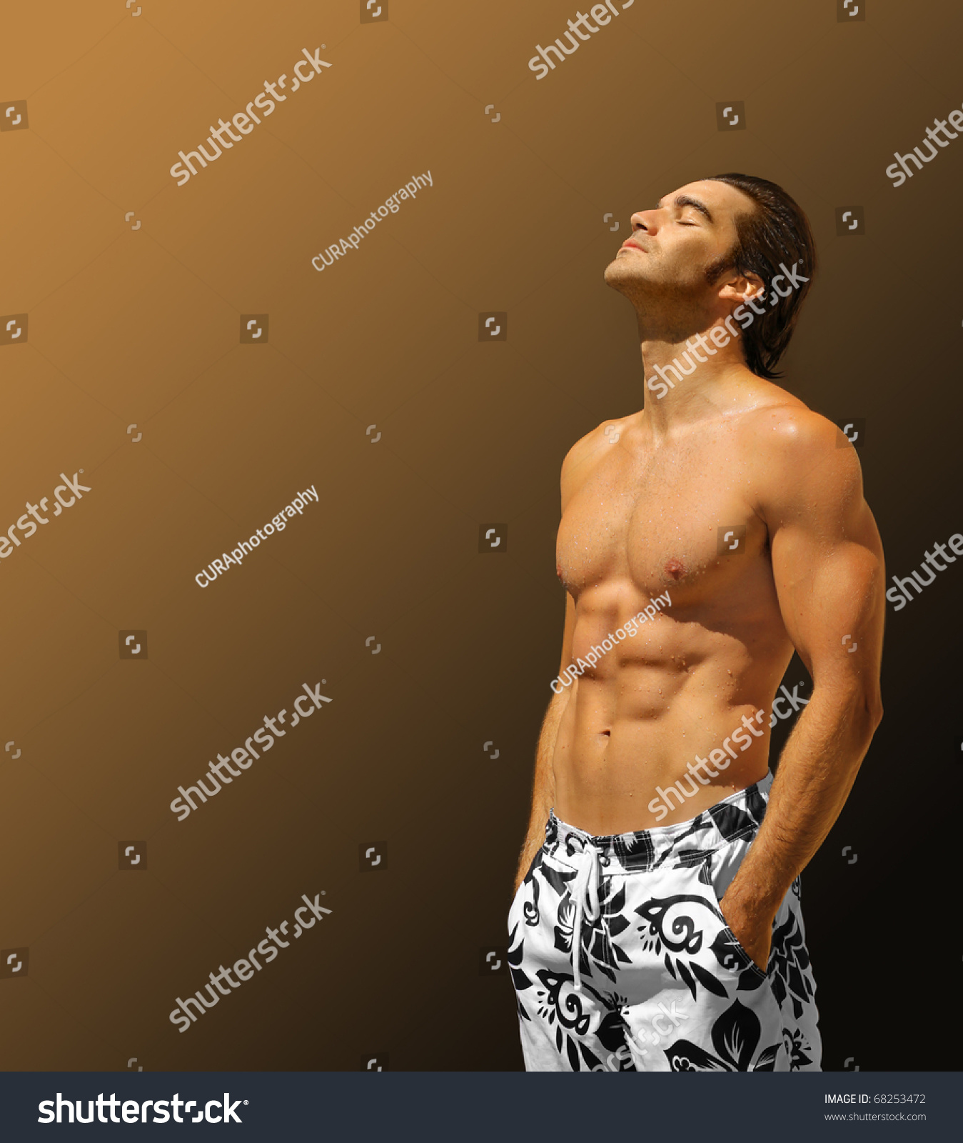 Handsome Male Fitness Model Shirtless With Hands In Pockets Looking Up With Lots Of Copy Space