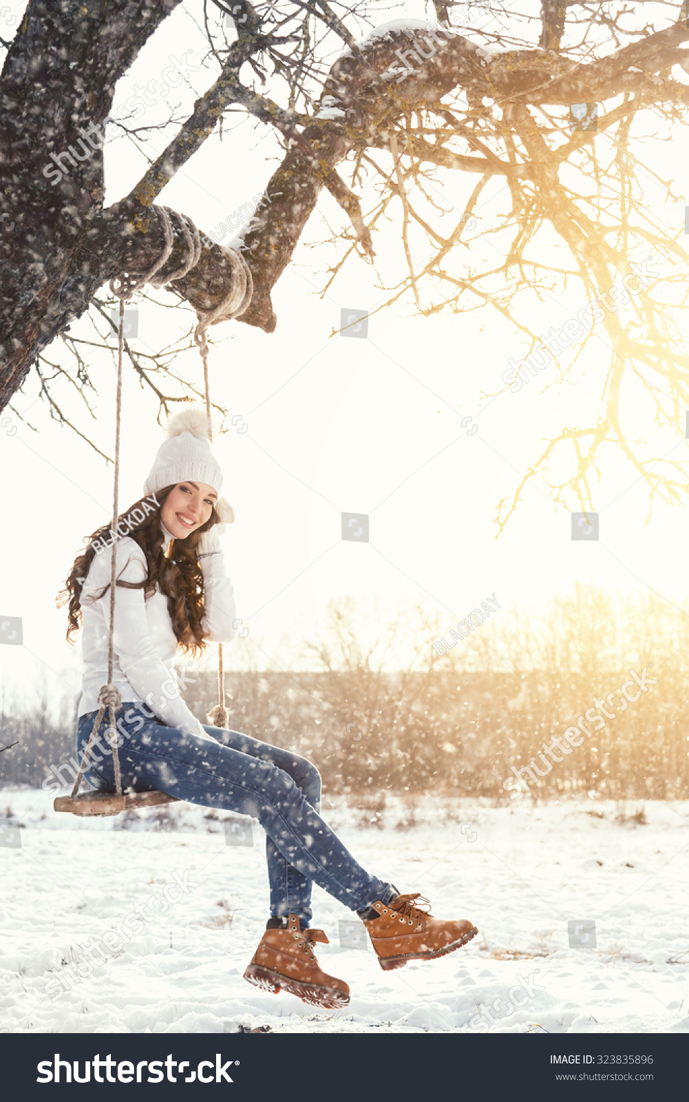 Happy girl and rope swing at sunny winter day Happy girl and rope swing at sunny winter day