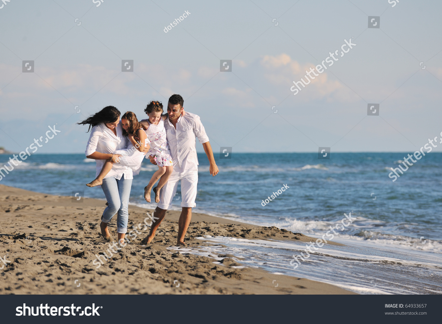 Happy Young Family In White Clothing Have Fun At Vacations On Beautiful