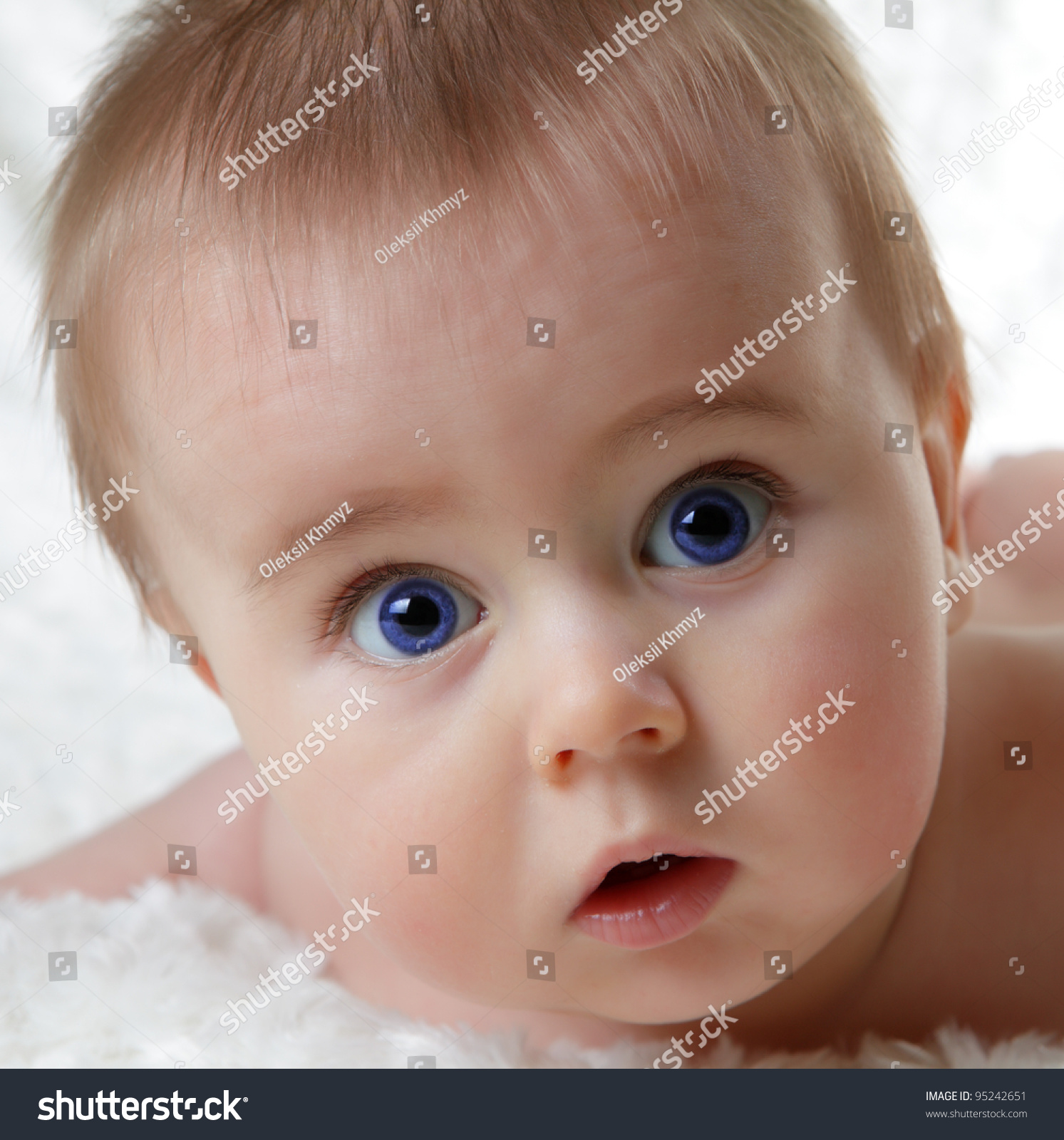 Head Shoot Of Cute Baby With Blue Eyes And Surprise Look Stock Photo
