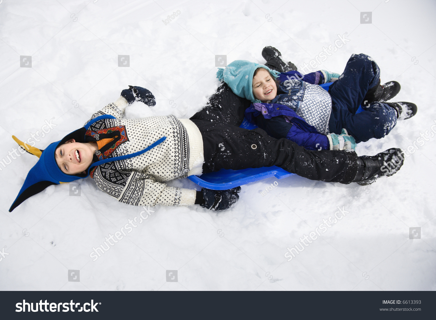 Wide Angle Photo Of The Lying On Snow High Angle View Of Caucasian Boy And Lying On Sled In