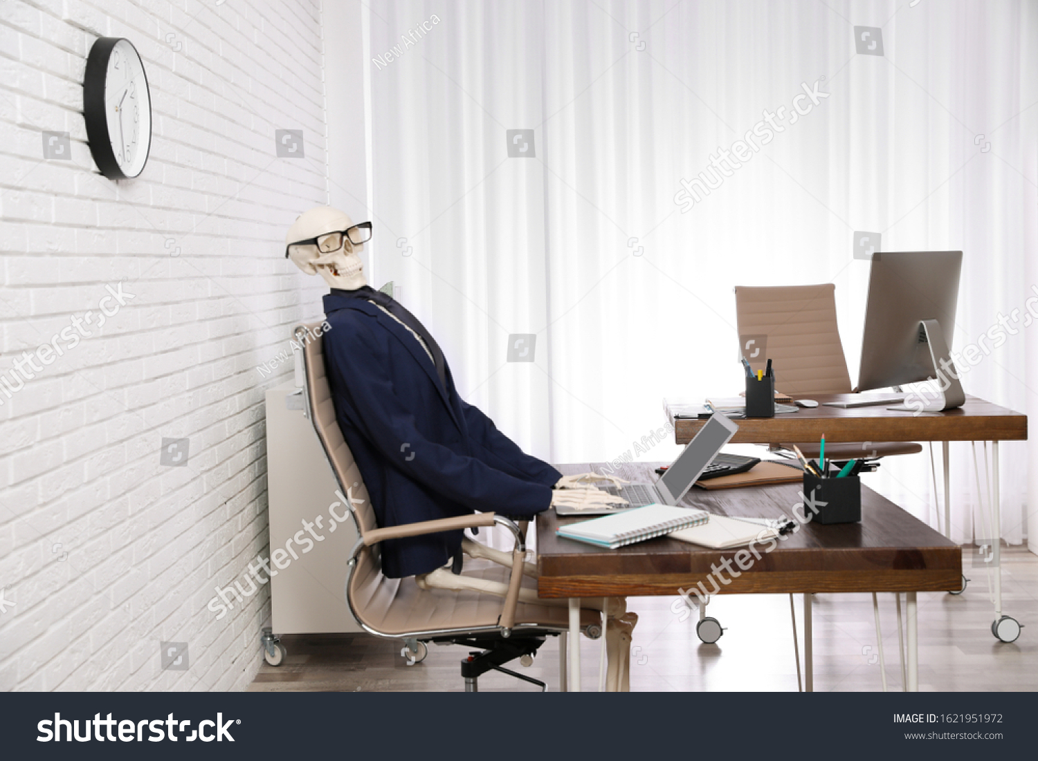 Human Skeleton Suit Using Laptop Table Stock Photo