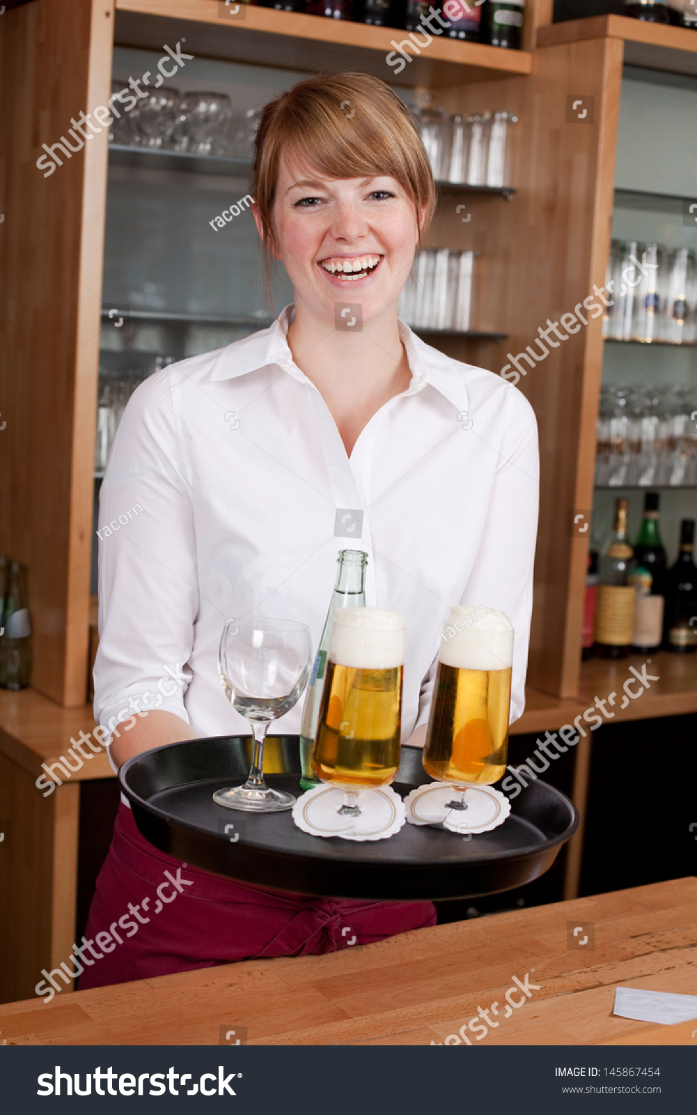 Laughing Young Female Waitress Or Bartender Serving Drinks In A Bar