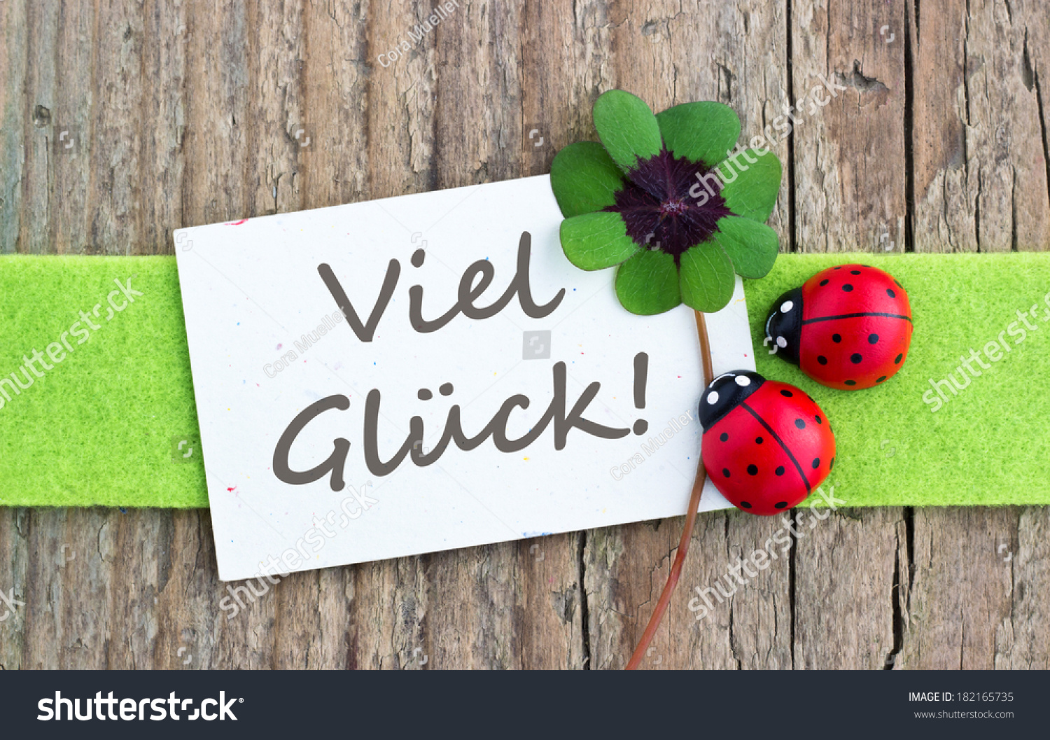 stock-photo-leafed-clover-ladybugs-and-card-on-wooden-board-good-luck-german-182165735.jpg