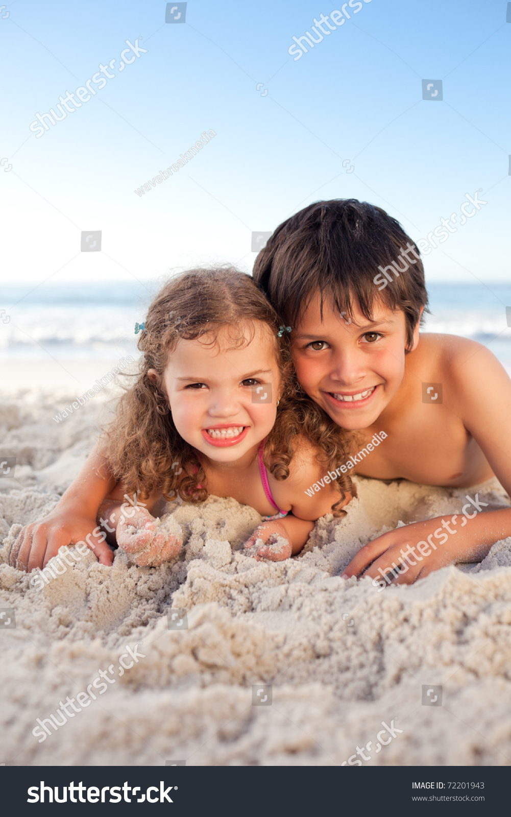 Little Boy And His Sister Lying Down On The Beach Stock 