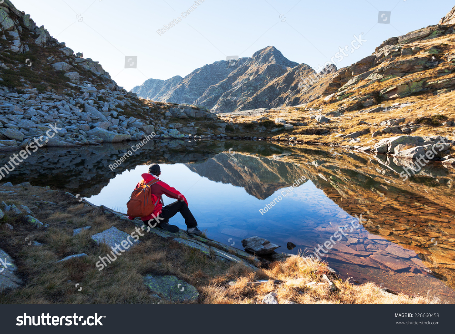 Hiker Takes A Rest Sitting Next A Mountain Lake Hiker Takes A Rest Sitting Next A Mountain Lake