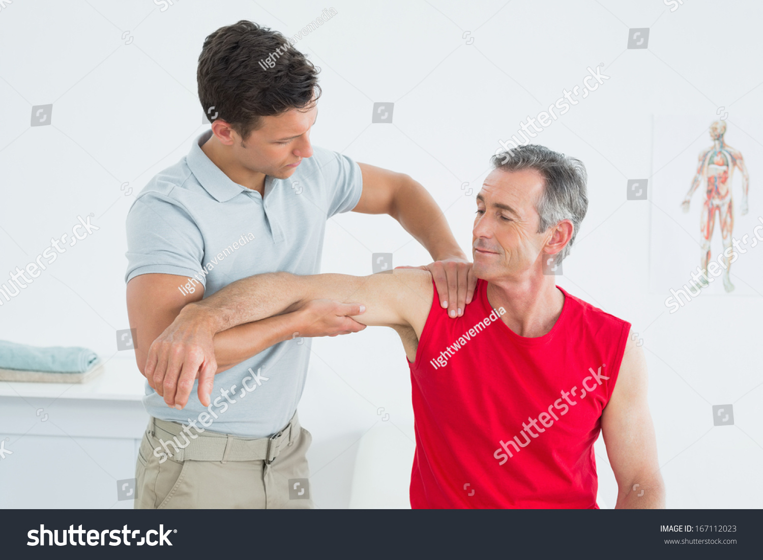 Male Physiotherapist Massaging Mature Mans Arm In The Hospital Sto