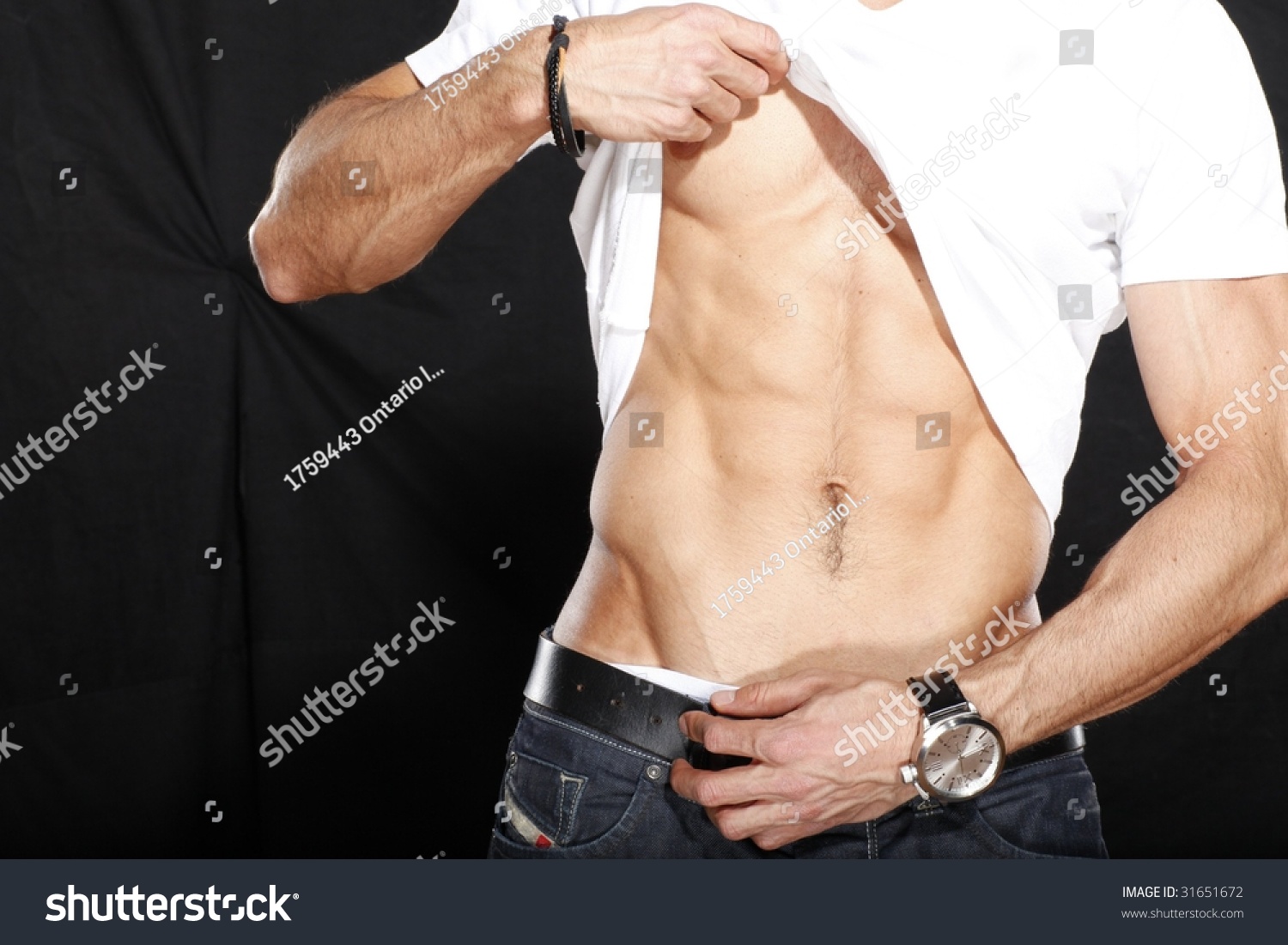 Man Lifting Up Shirt To Show Off His Rock Hard Abs Stock Photo