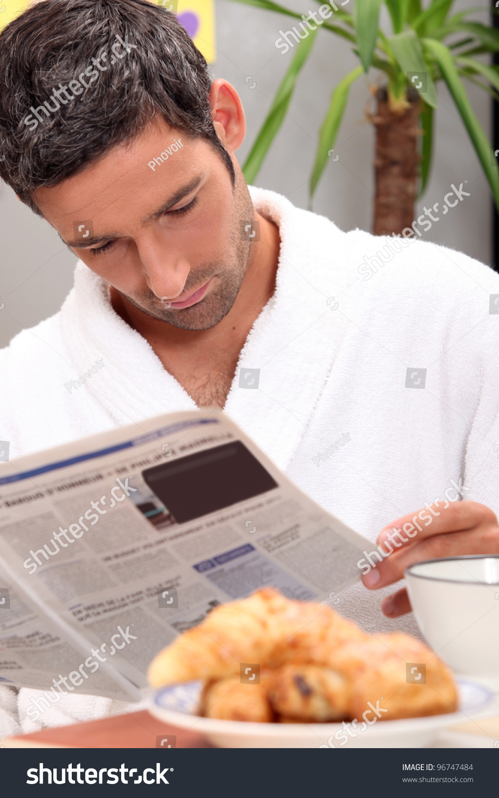 Man reading a journal over breakfast Man reading a journal over breakfast
