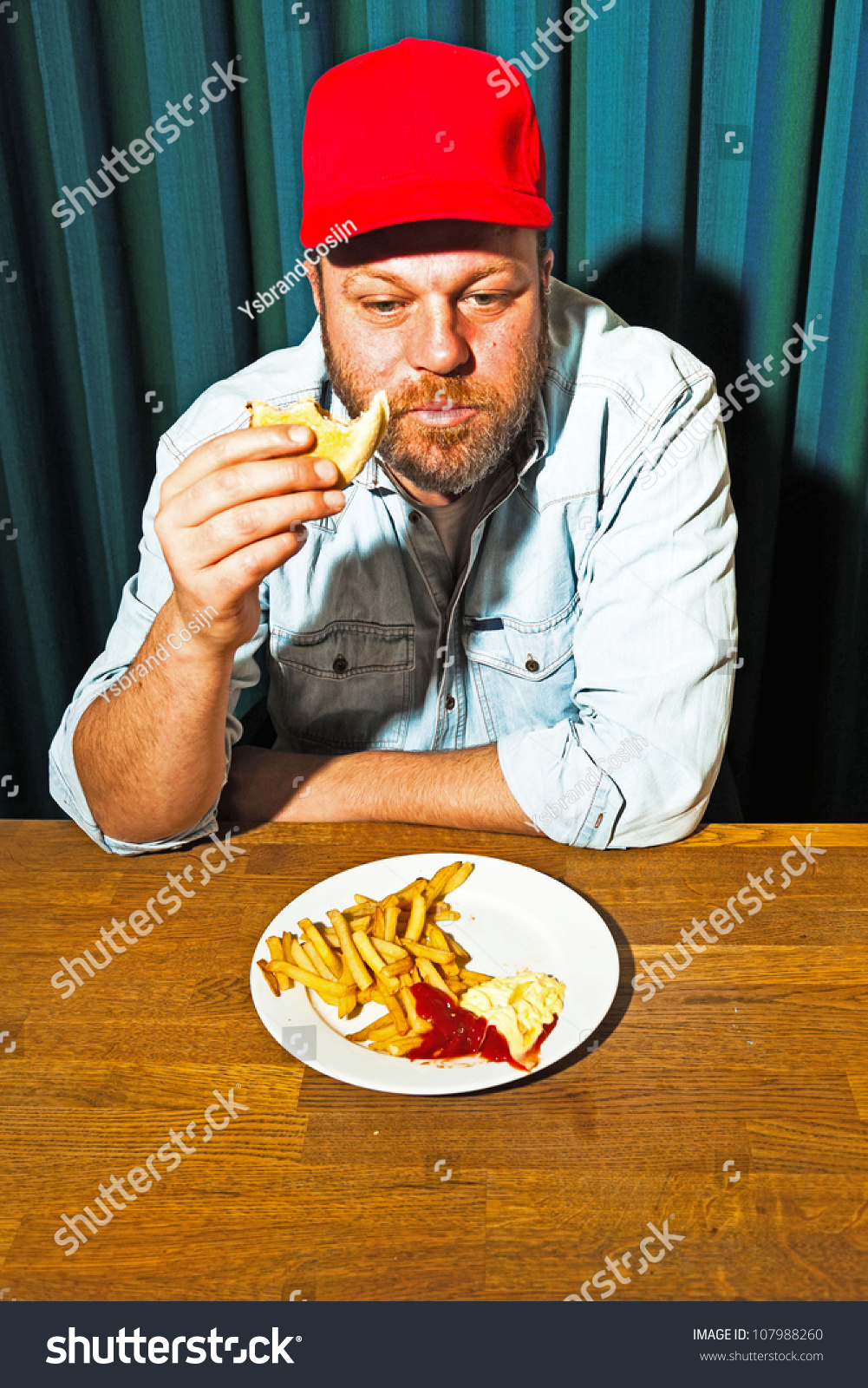 Man With Beard Eating Fast Food Meal. Enjoying French Fries And A