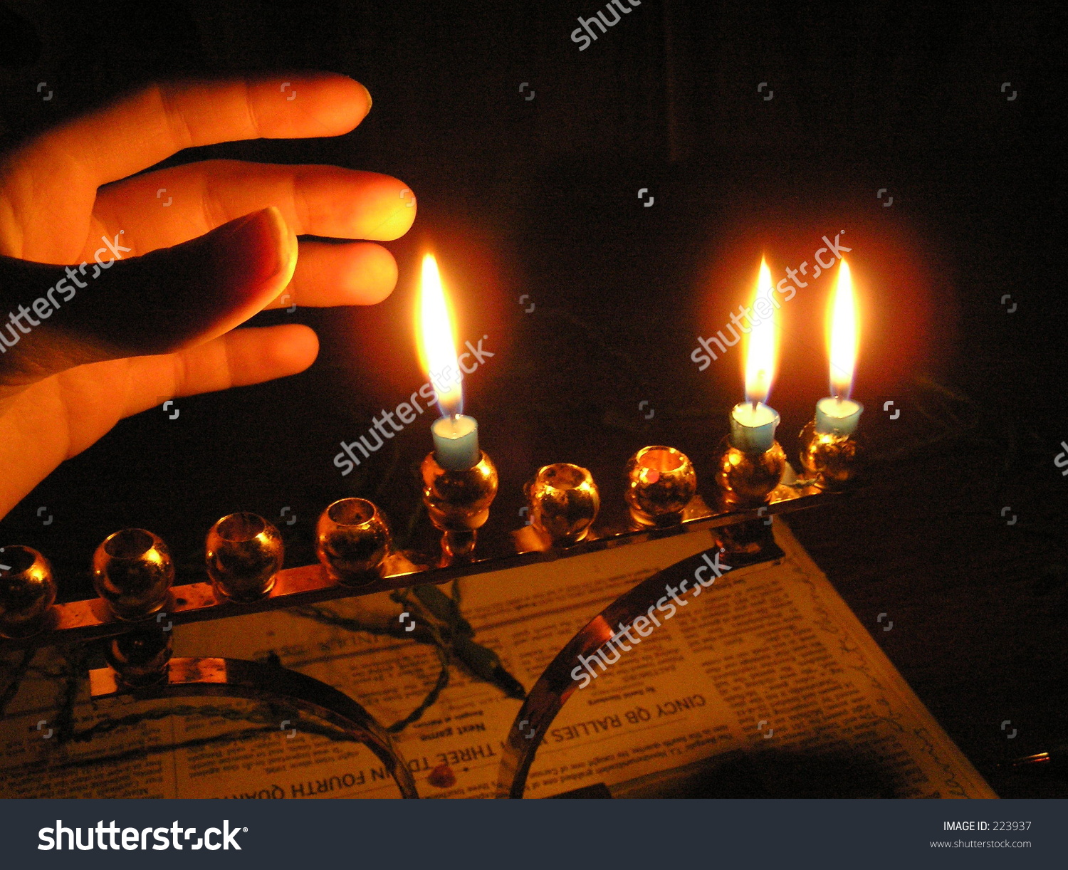 Menorah On The 2nd Night Of Chanukah; Hand In The Glow. Stock Photo