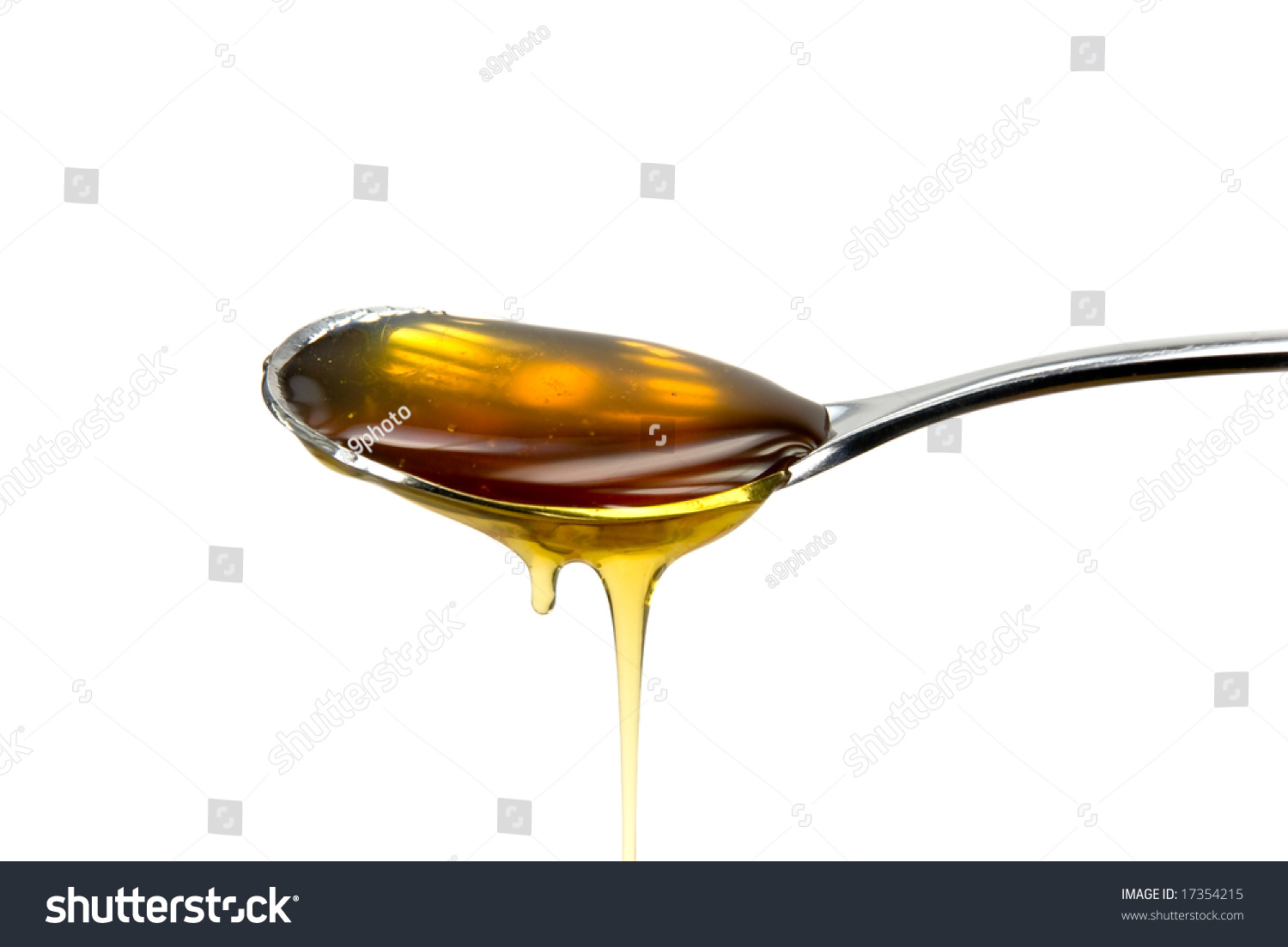 Metal Spoon Filled With Honey Over A White Background Stock Photo 