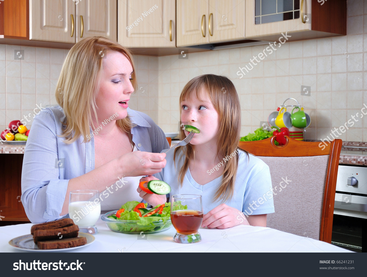 Mom And Young Daughter Eating Breakfast Together In The Kitchen Stock ...