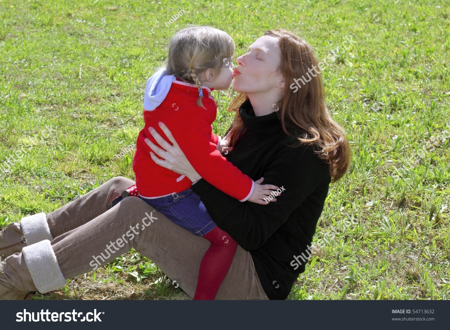 Mother And Daughter Kissing Mouth Lips Hug In Winter Meadow Grass Stock