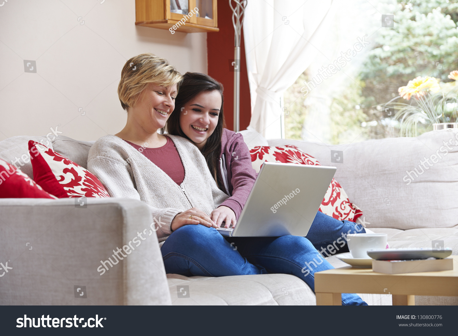 Mother And Daughter Smiling At Laptop While Using Webcam Stock Photo