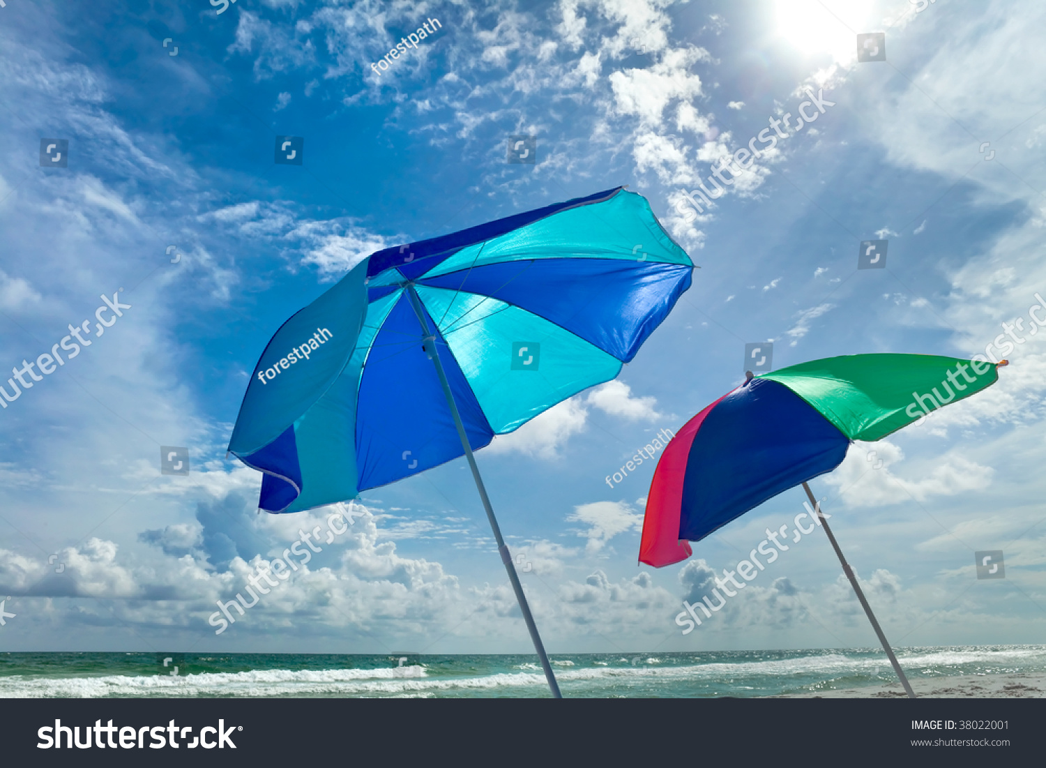 Multicolored Beach Umbrellas Blowing In The Wind On A Bright Sunny Day