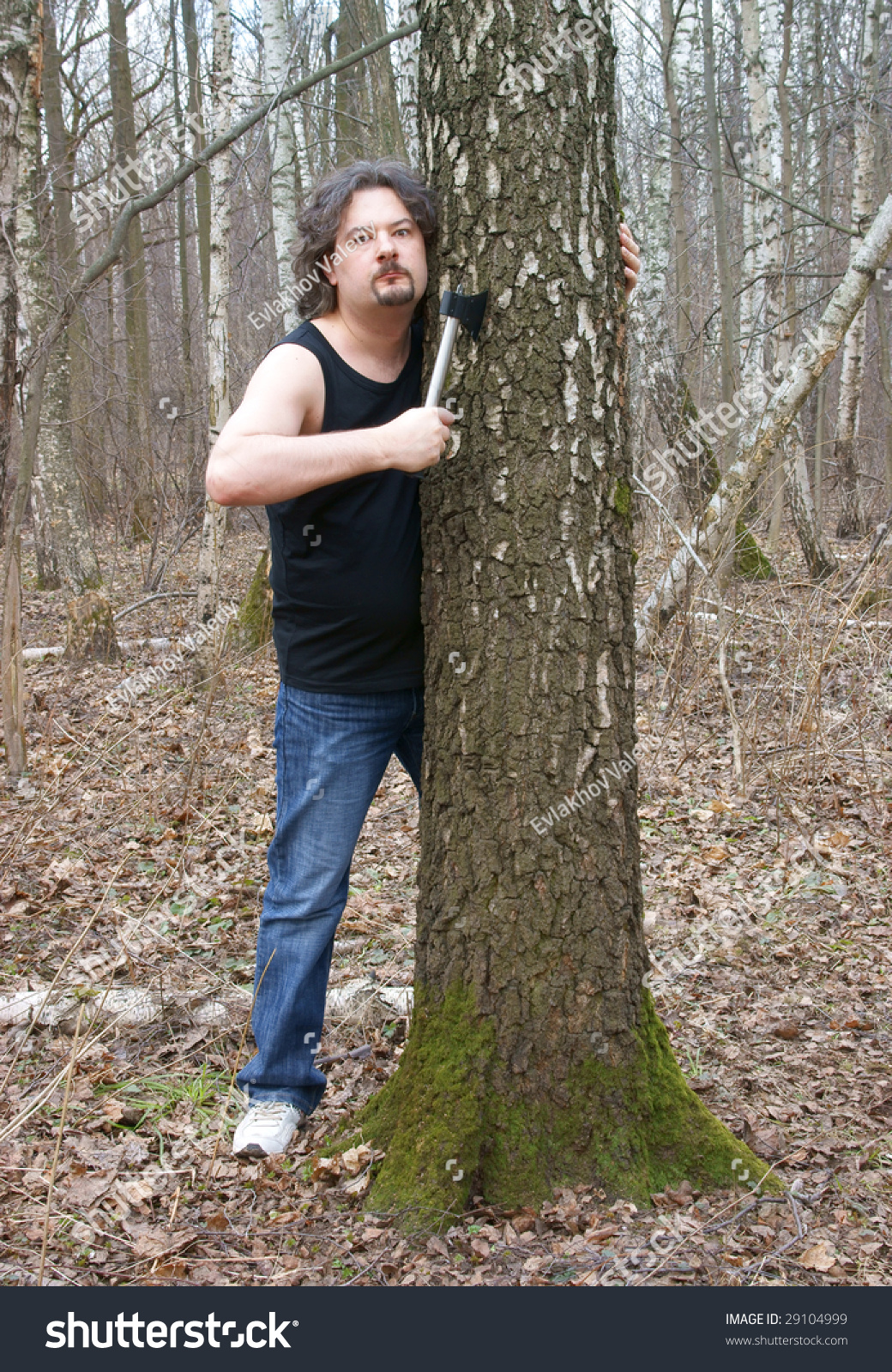 Murderer With Axe Tree In Forest Murderer With Axe Tree In Forest Stock Photo