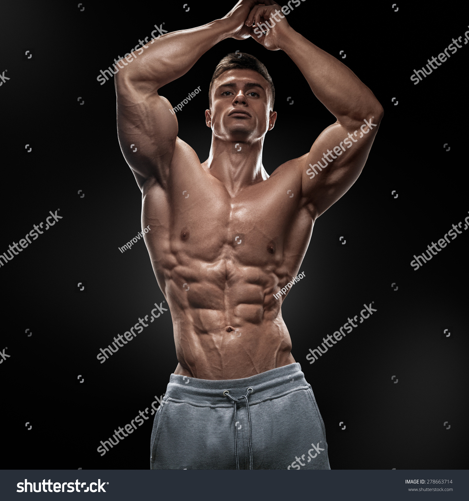 Muscular And Fit Young Bodybuilder Fitness Male Model Posing Over Black