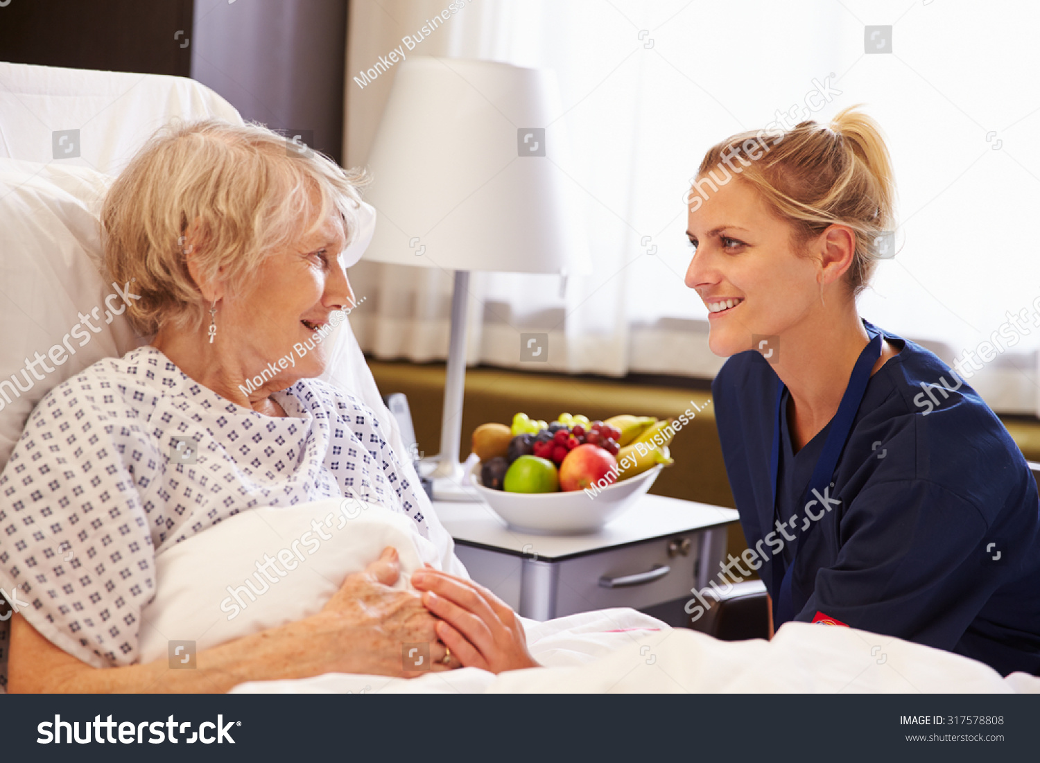 Nurse Talking To Senior Female Patient In Hospital Bed Stock Photo ...