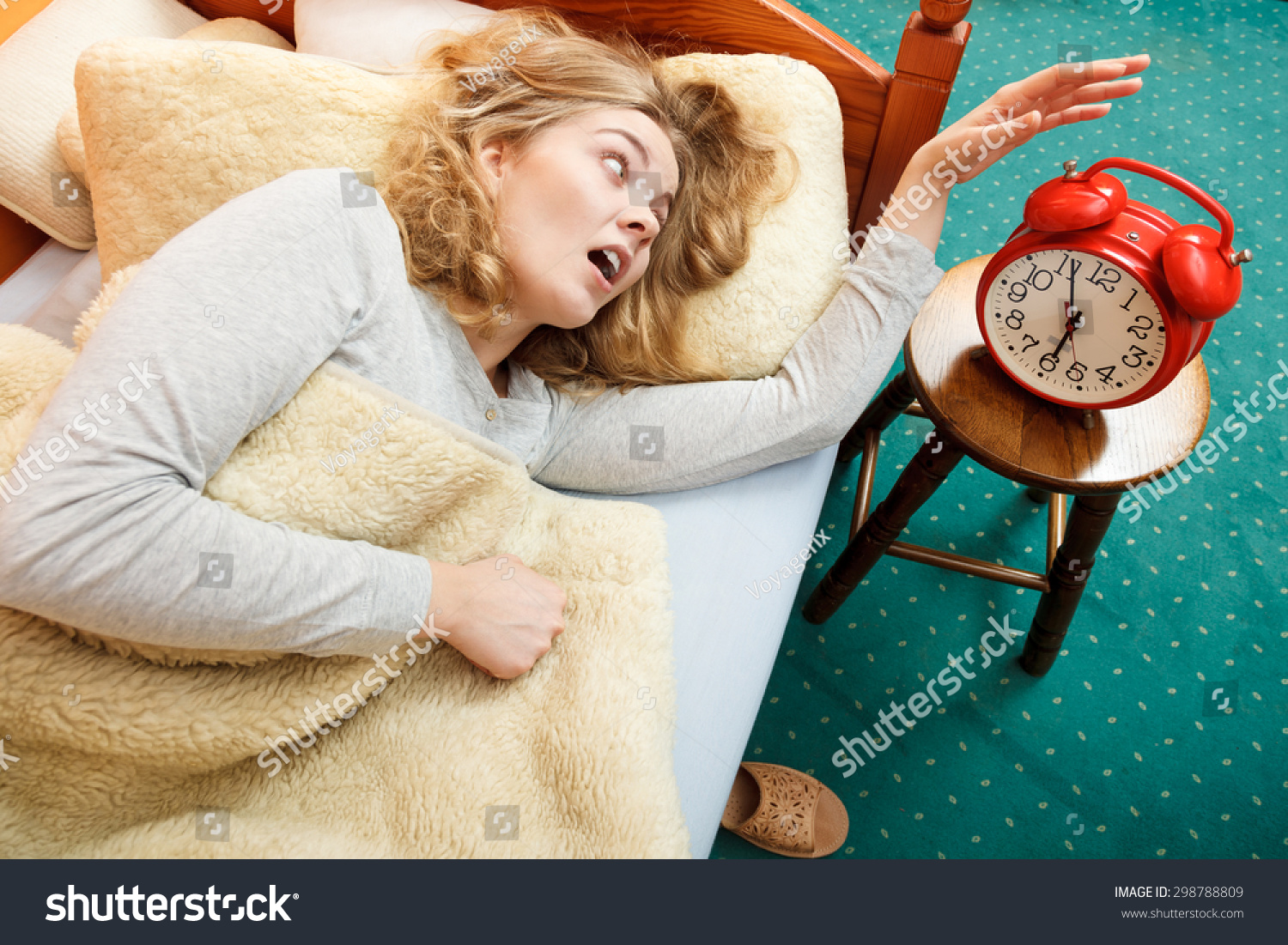 Panic woman waking up late in morning turning off alarm clock Young girl laying in bed Panic woman waking up late in morning turning off alarm clock Young girl laying in bed