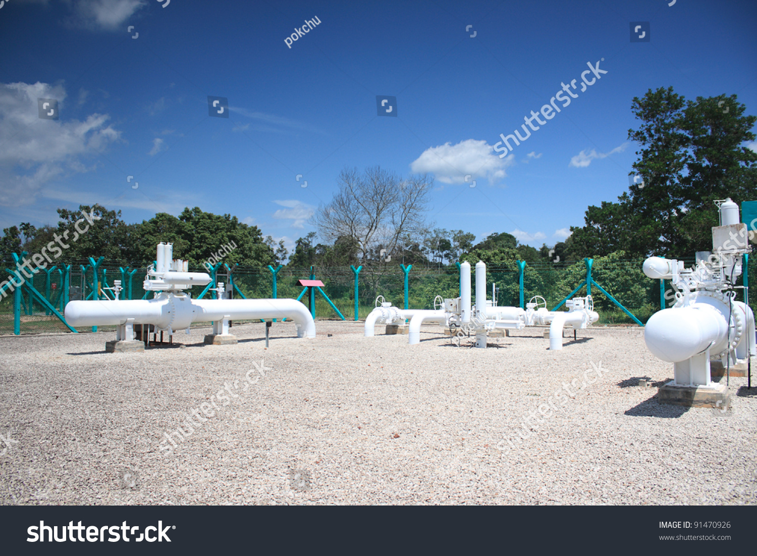 Pipeline Block Valve Station. White Above Ground Pipe And Green Fence
