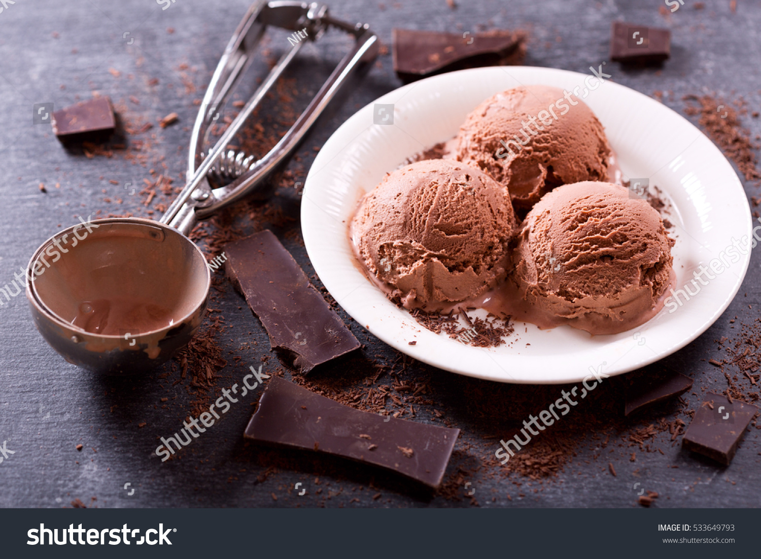 plate of chocolate ice cream scoops on dark background plate of chocolate ice cream scoops on dark background