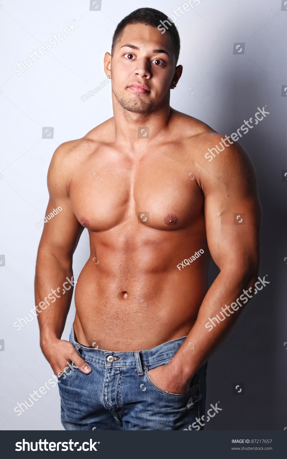 Portrait Of A Macho Man Against Grey Background Imagen de archivo