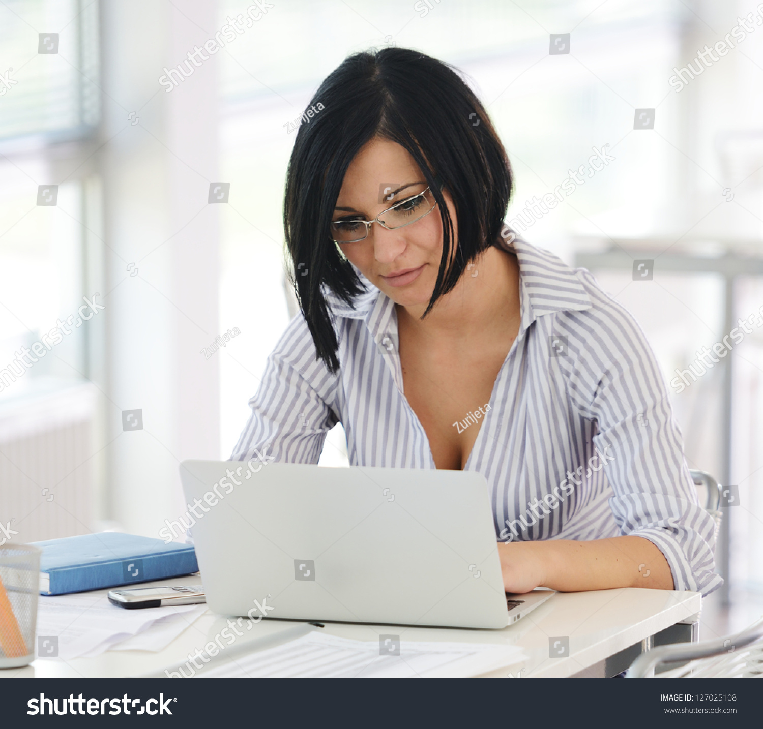 Portrait Of A Pretty Businesswoman Sitting At Her Desk With A Laptop