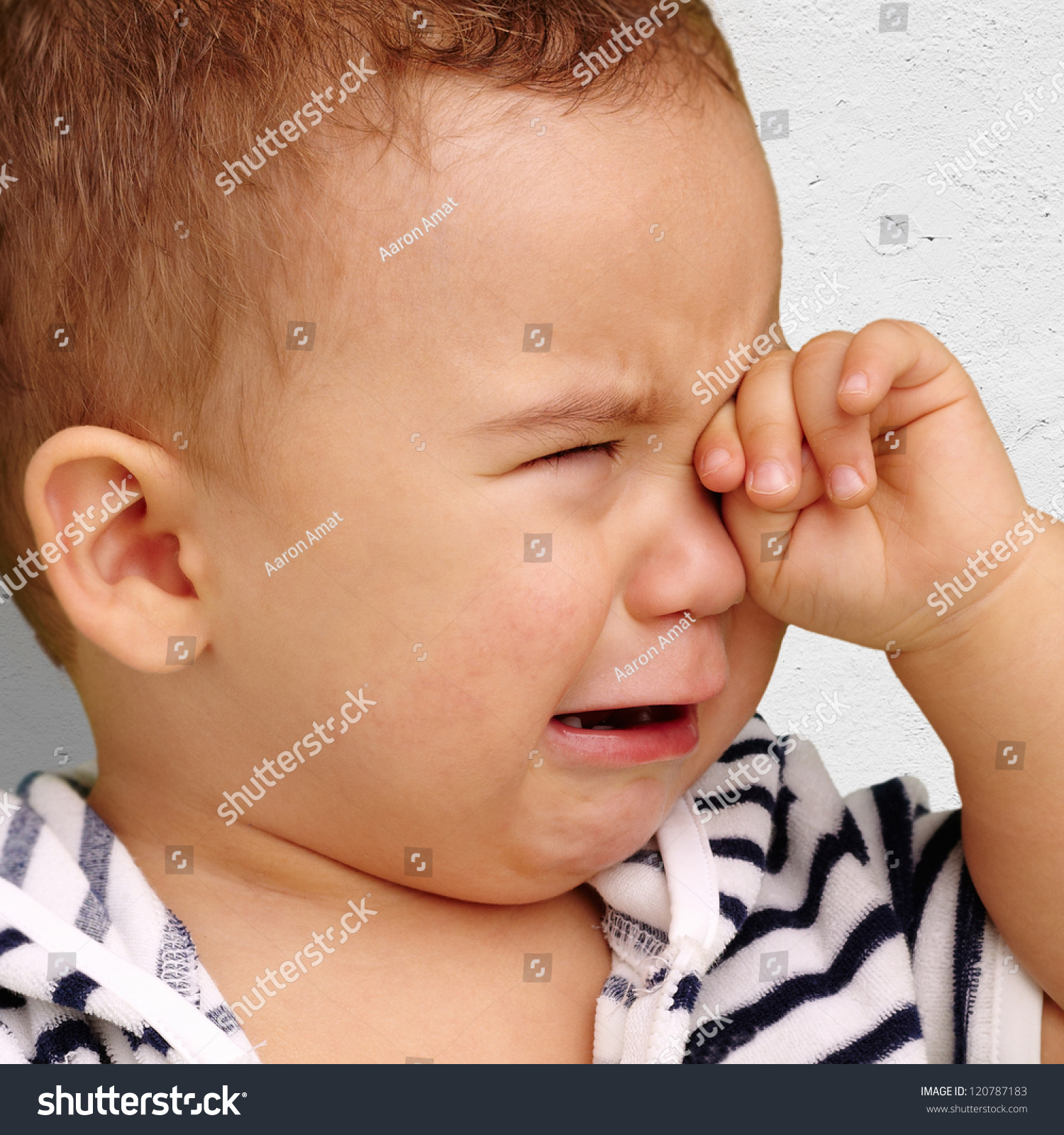 Portrait Of Baby Boy Crying Against A Grunge Background Stock Photo