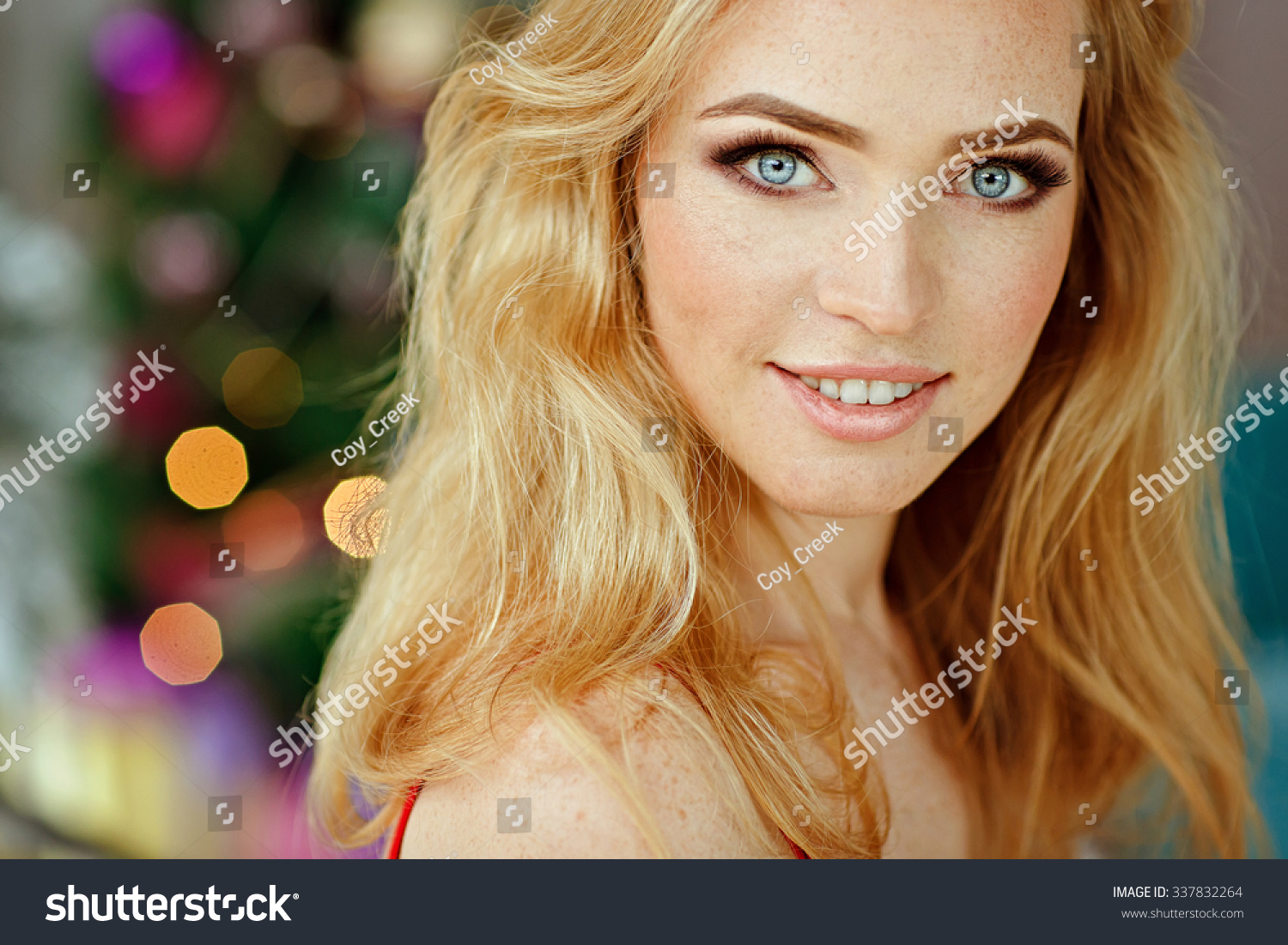 Portrait Of Blond Sensual Blue Eyed Girl With Freckles In A White Fur Cape On The Christmas