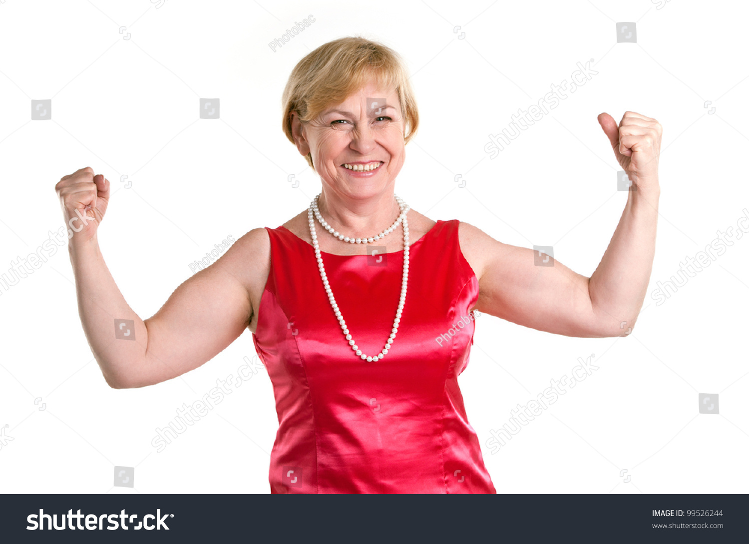 Portrait Of Fit Senior Woman Flexing Her Biceps Against White