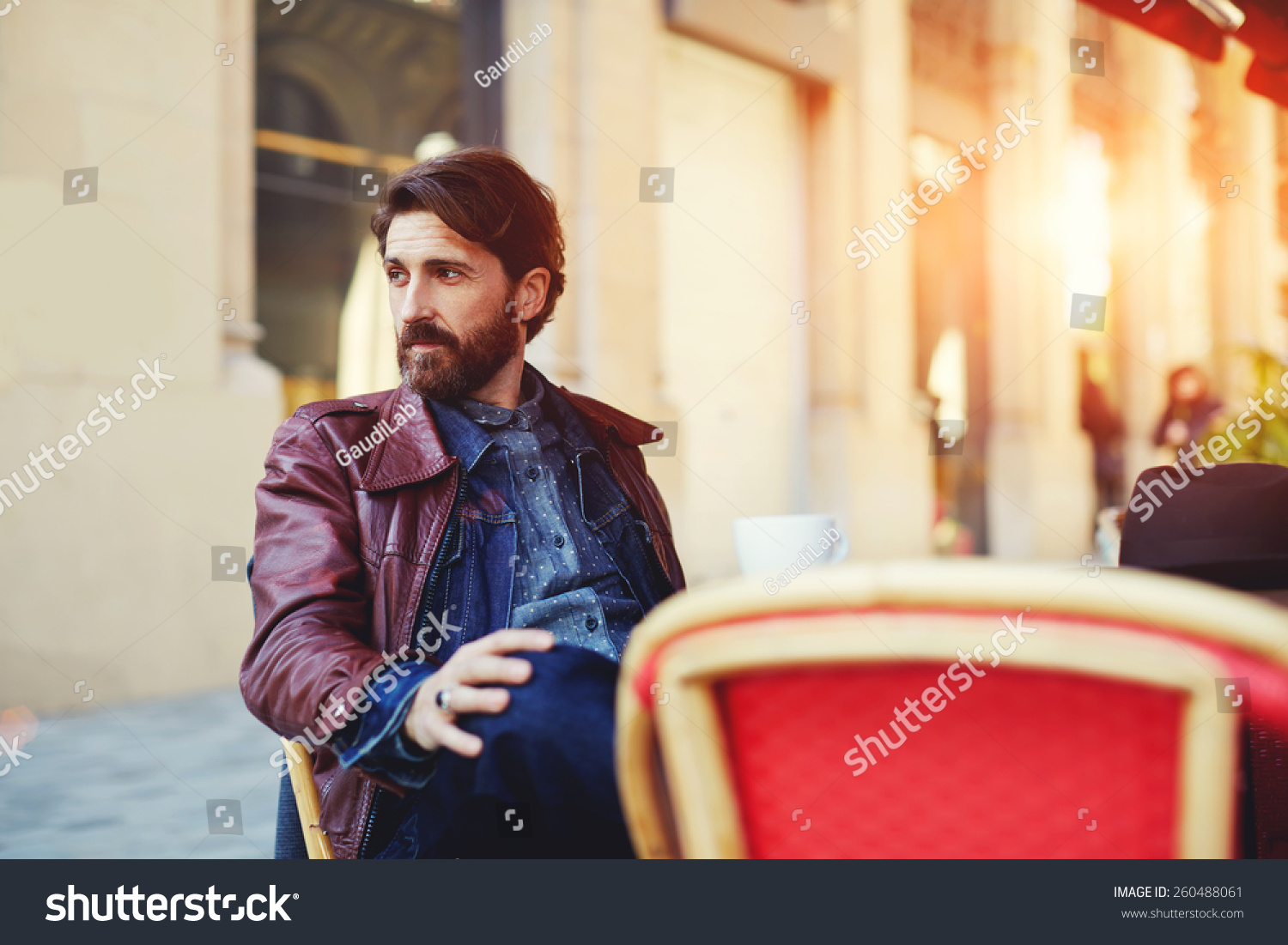 Portrait of handsome and stylish man with beard enjoying a cup of coffee in a coffee shop adult fashionable hipster having coffee in beautiful cafe terrace at sunny day flare sun light Portrait of handsome and stylish man with beard enjoying a cup of coffee in a coffee shop adult fashionable hipster having coffee in beautiful cafe terrace at sunny day flare sun light