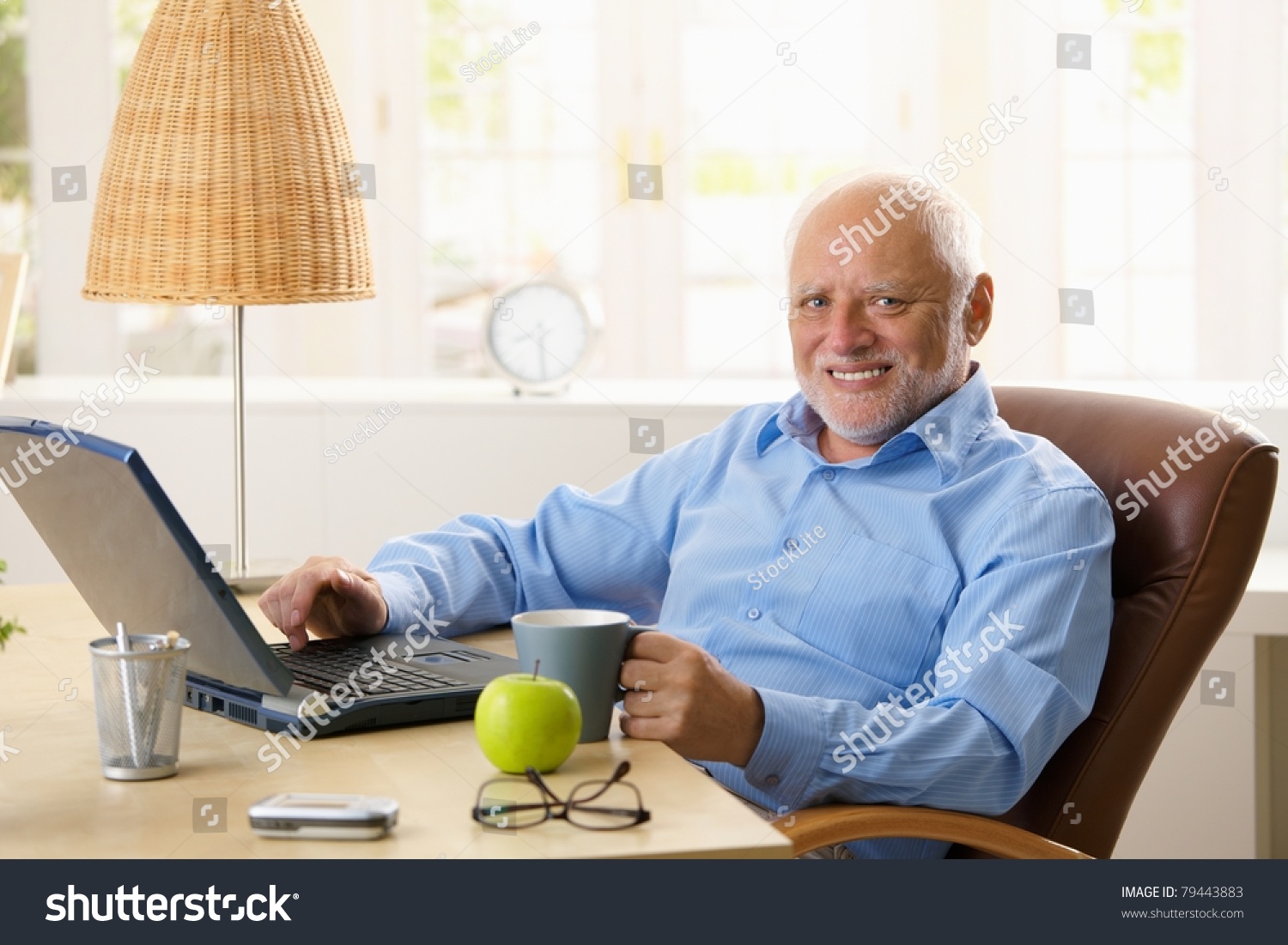 stock-photo-portrait-of-happy-senior-man-sitting-at-desk-using-laptop-computer-at-home-smiling-at-camera-79443883.jpg