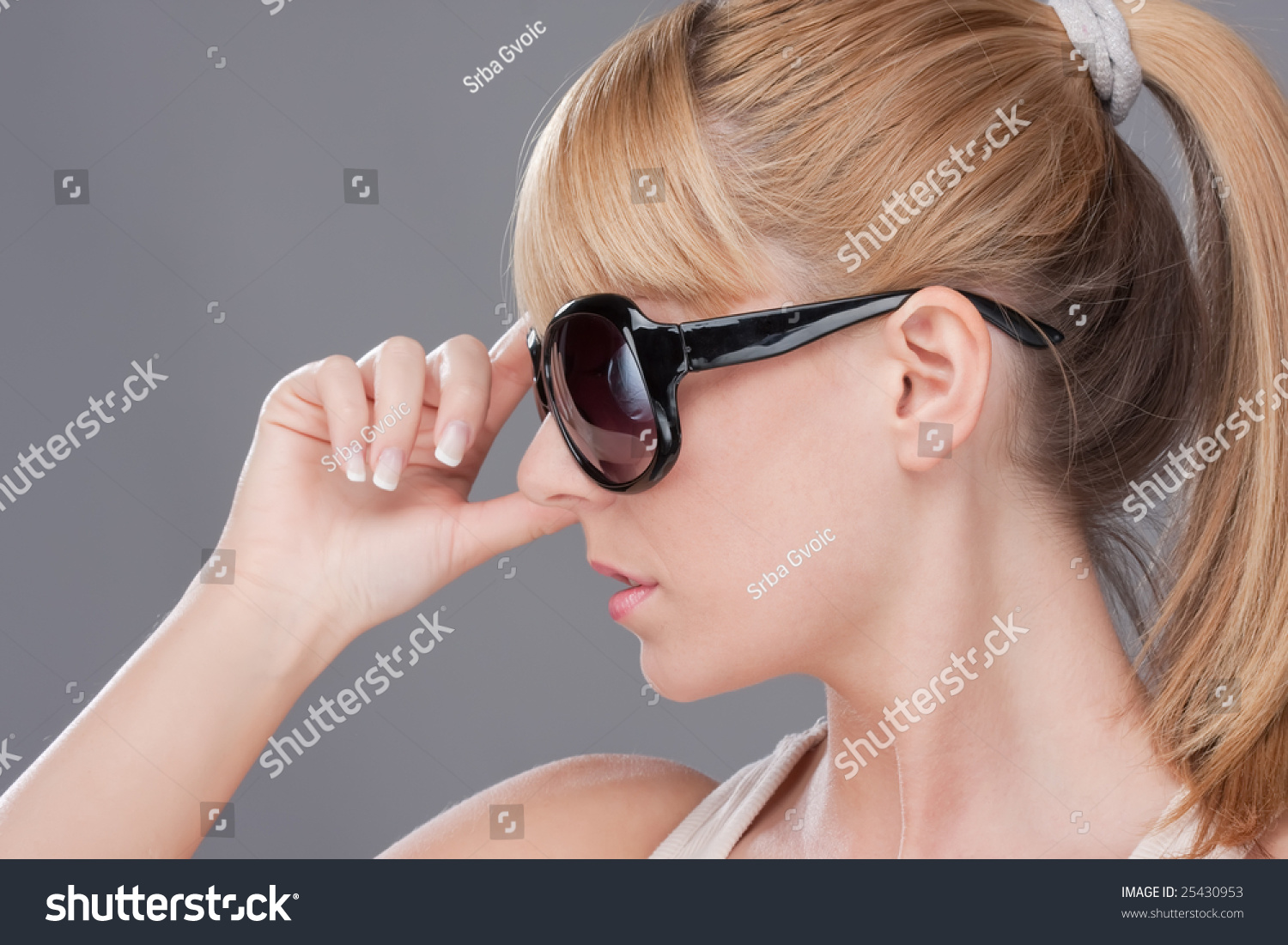 Of blond teen holding sunglasses