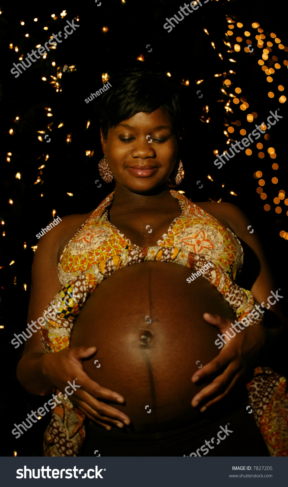 Pregnant African American Woman Posing In Front Of Night Light Setting 