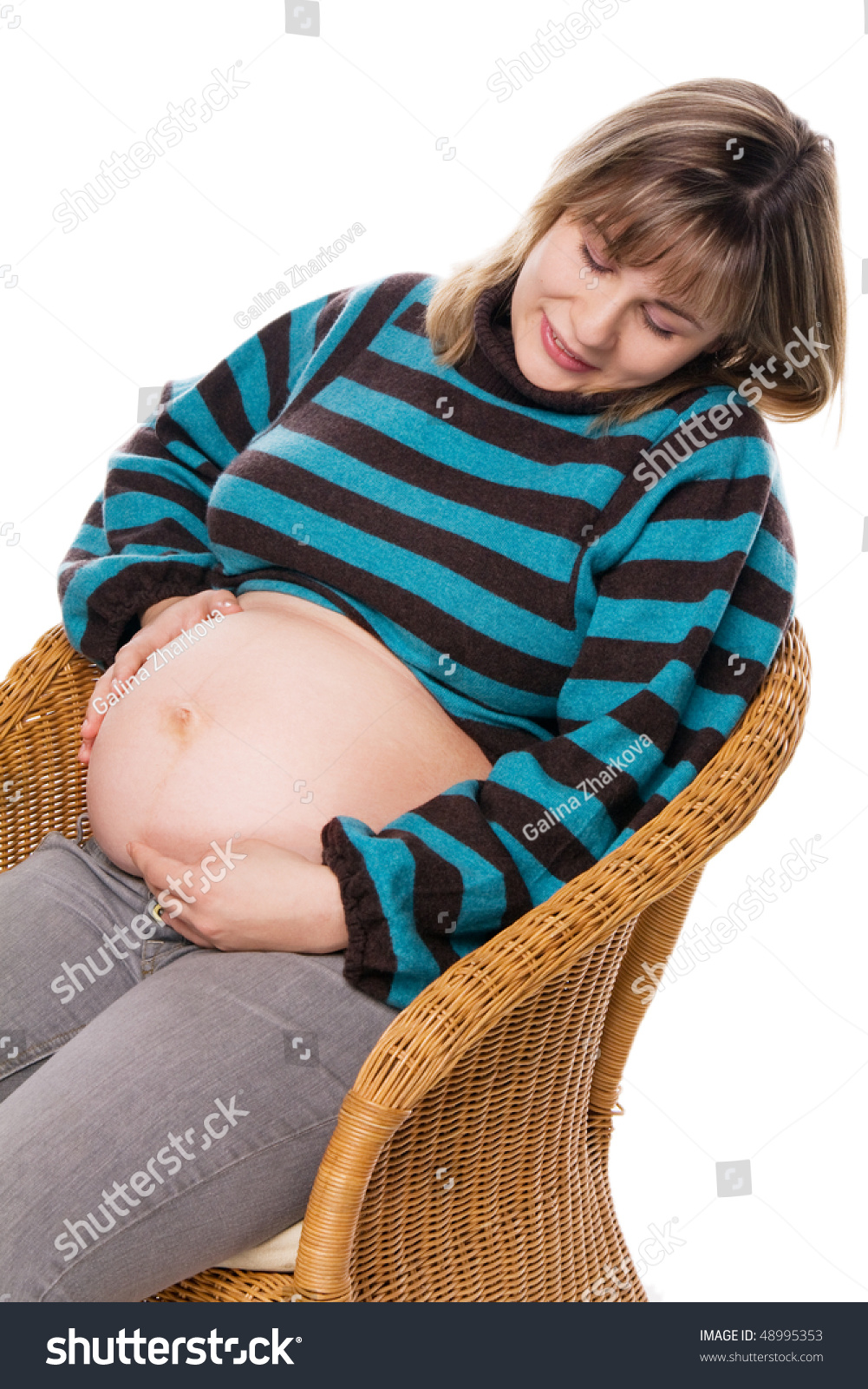 Pregnant Woman Sitting On A Wicker Chair And Hugs Naked Belly Isolated