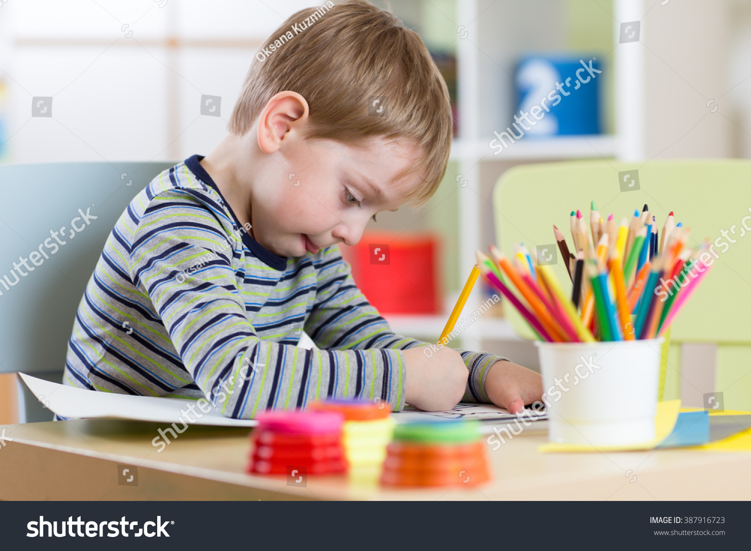 Preschool child use pencils and paints for homework received from kindergarten Preschool child use pencils and paints for homework received from kindergarten