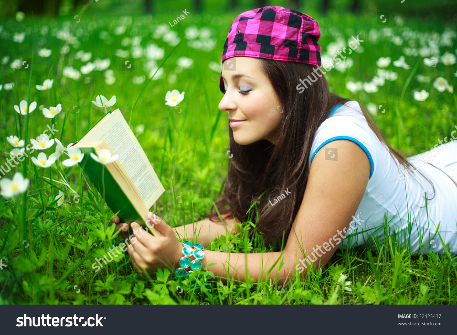 Pretty Brunette Girl Reading A Book In The Park In Summertime Stock