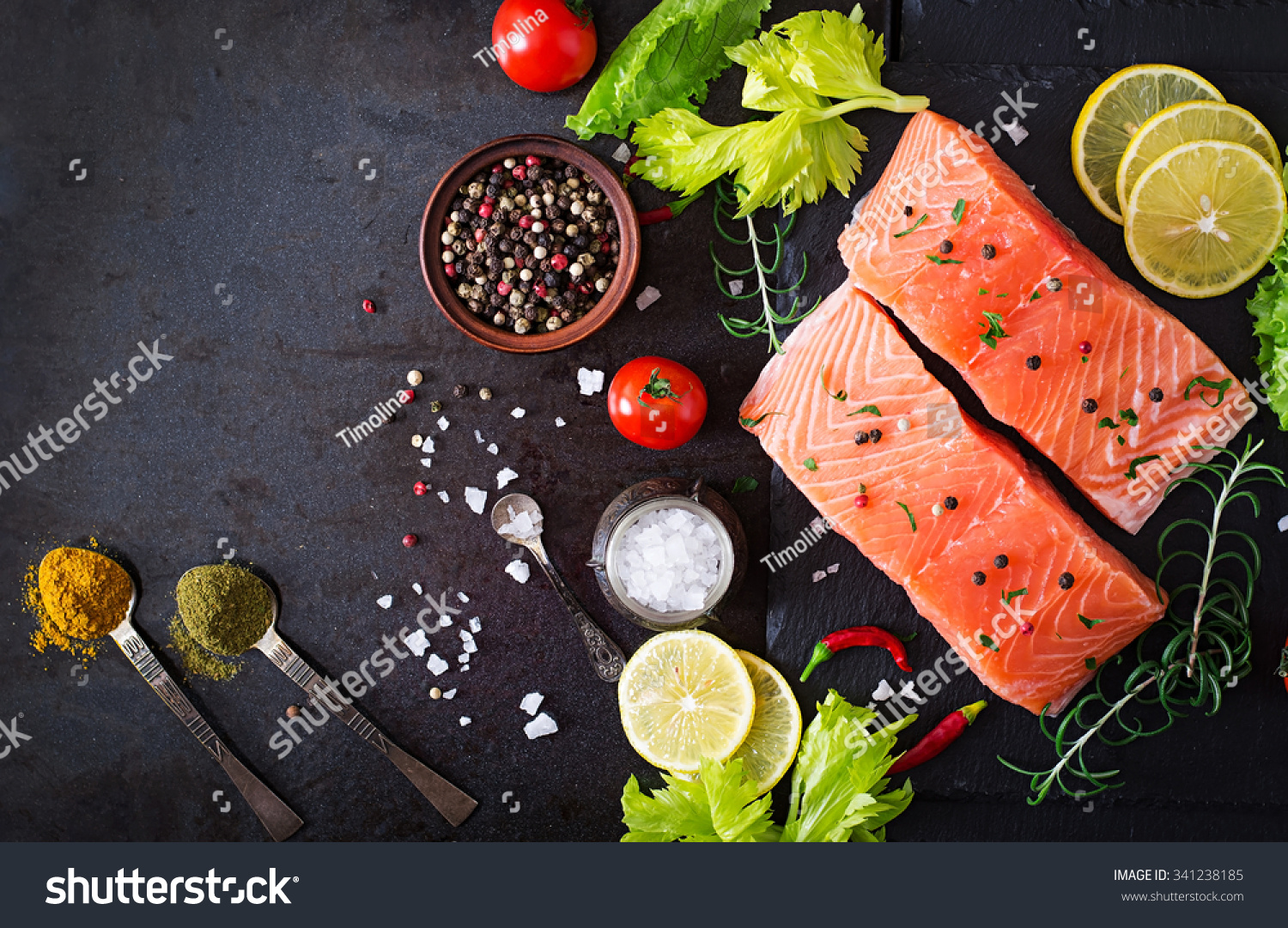 Raw salmon fillet and ingredients for cooking on a dark background in a rustic style Top view Raw salmon fillet and ingredients for cooking on a dark background in a rustic style Top view