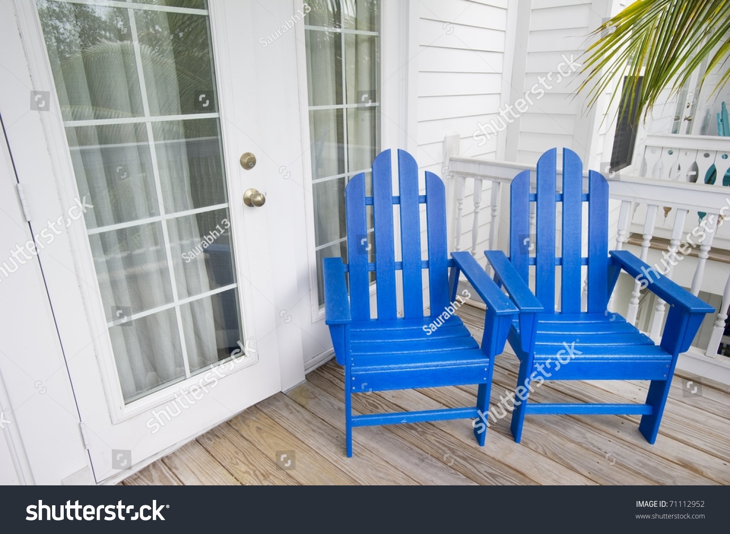Relaxing Depiction Of Blue Adirondack Chairs In Key West Florida With A