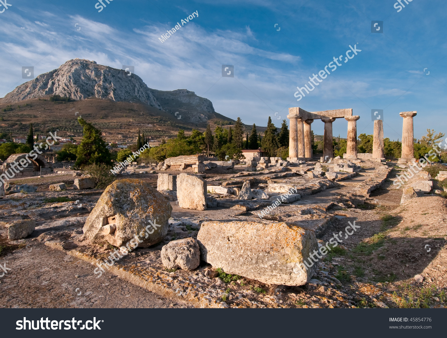 Ruins Of Temple Of Apollo, Ancient Corinth, Greece With Hill Fortress ...