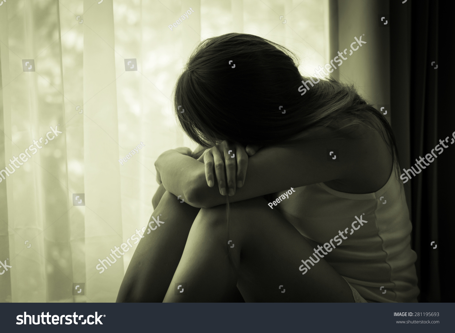 Sad girl looking out of window black and white filtered Sad girl looking out of window black and white filtered