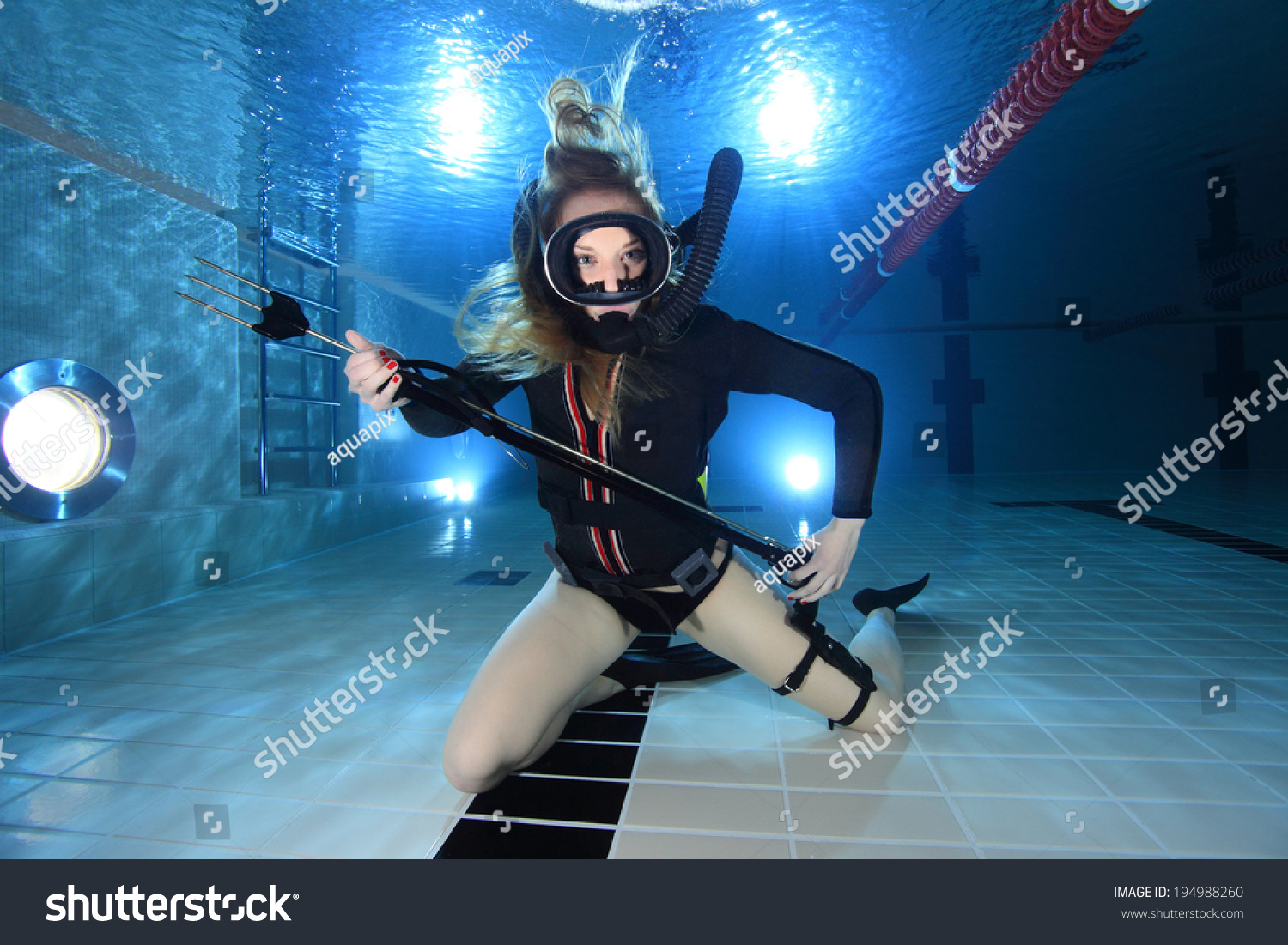 Scuba Woman With Black Neoprene Dress And Spear Gun Diving Underwater